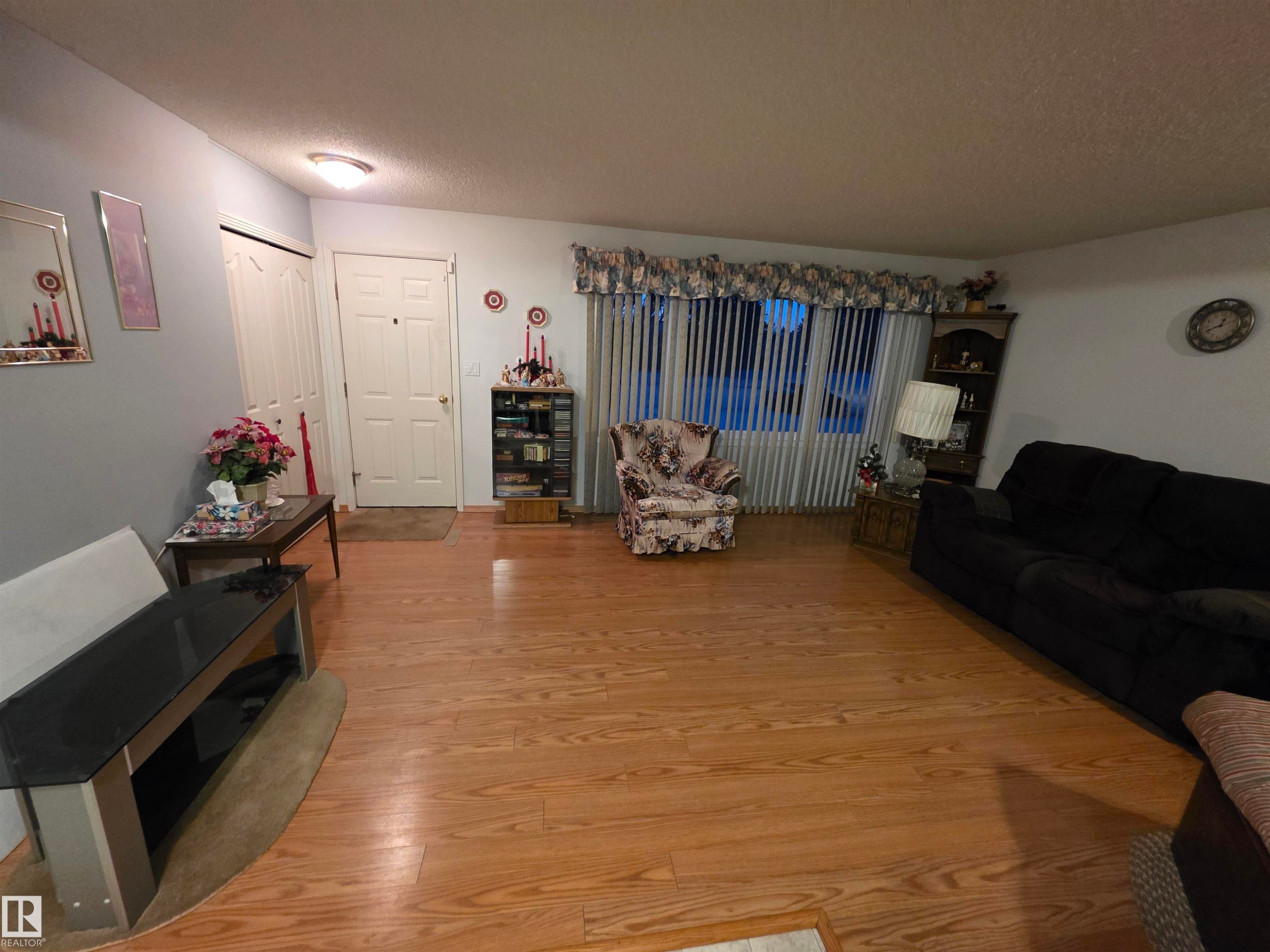 Living area with a textured ceiling and light wood-style floors - 4400 45 Avenue, Stony Plain, AB - Indoor Photo Showing Living Room