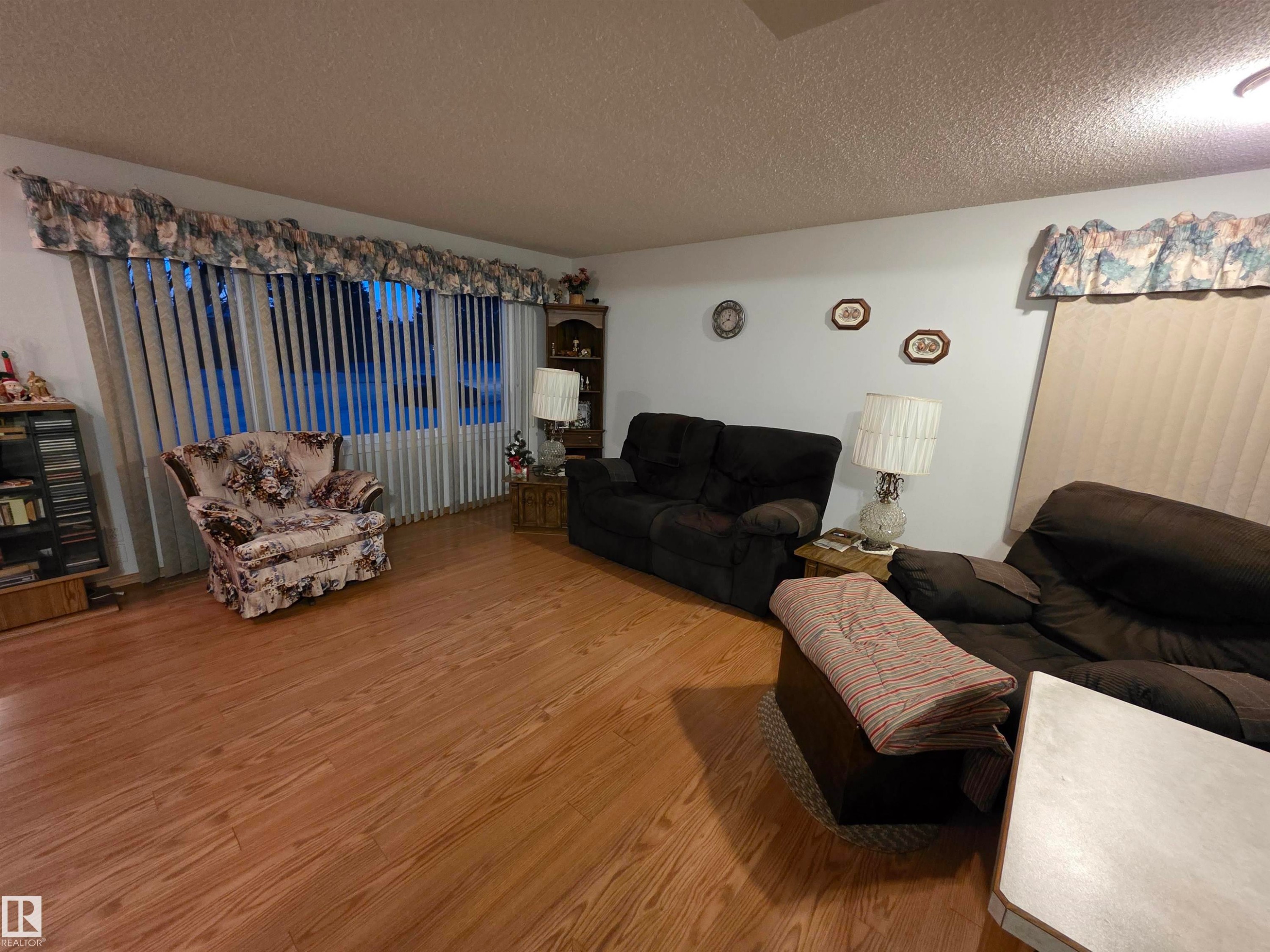 Living area with a textured ceiling and wood finished floors - 4400 45 Avenue, Stony Plain, AB - Indoor Photo Showing Living Room