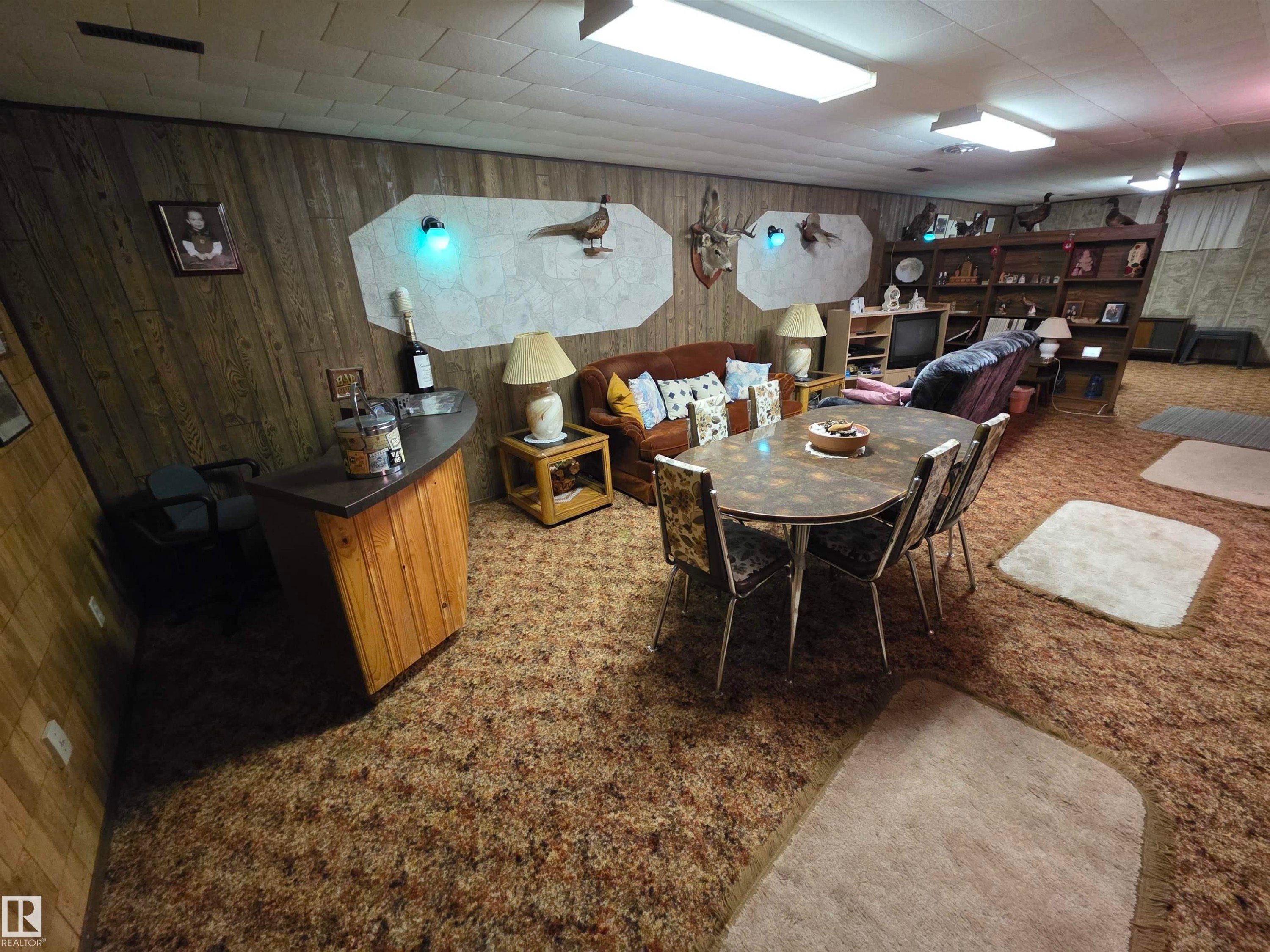Dining area featuring light carpet and wood walls - 4400 45 Avenue, Stony Plain, AB - Indoor