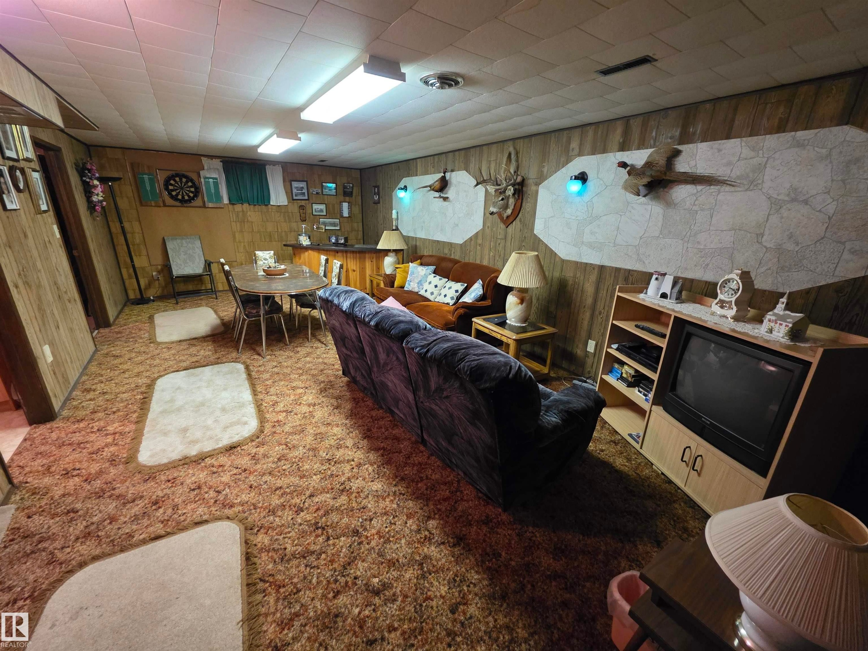 Carpeted living room with wood walls - 4400 45 Avenue, Stony Plain, AB - Indoor