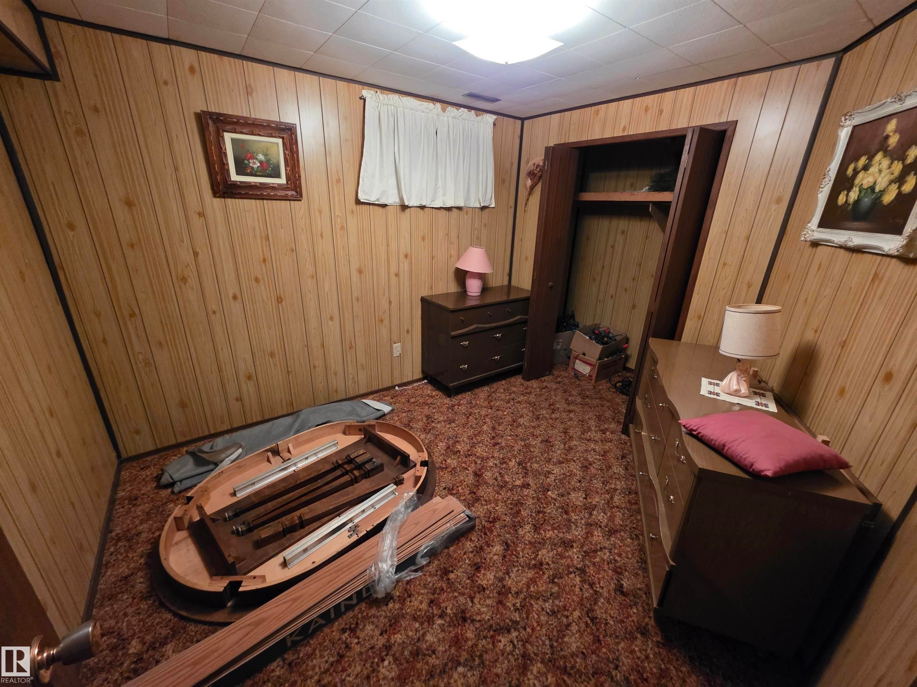 Bedroom with dark carpet, a closet, and wood walls - 4400 45 Avenue, Stony Plain, AB - Indoor Photo Showing Other Room