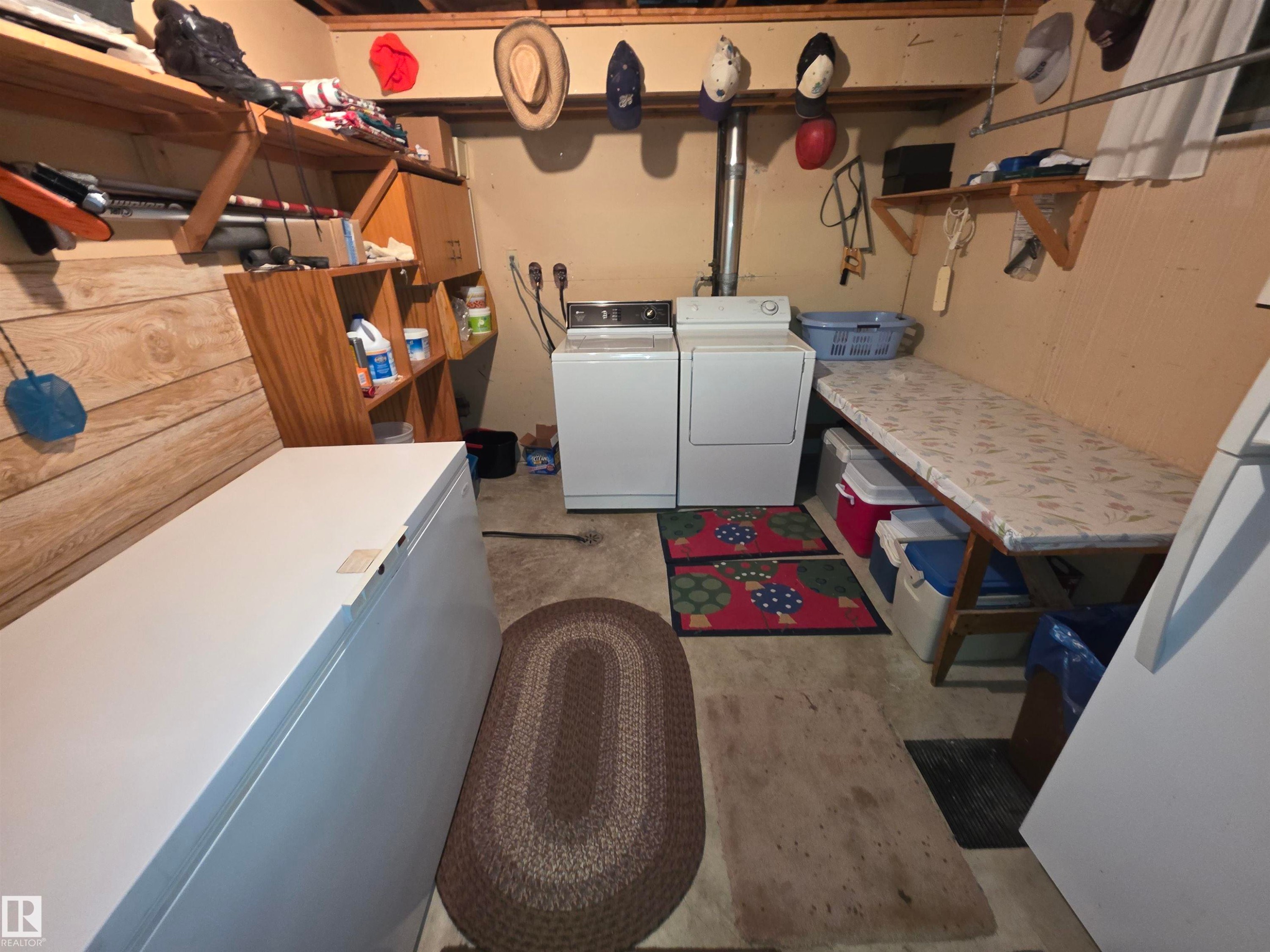 Laundry area featuring unfinished concrete flooring and washer and clothes dryer - 4400 45 Avenue, Stony Plain, AB - Indoor Photo Showing Laundry Room