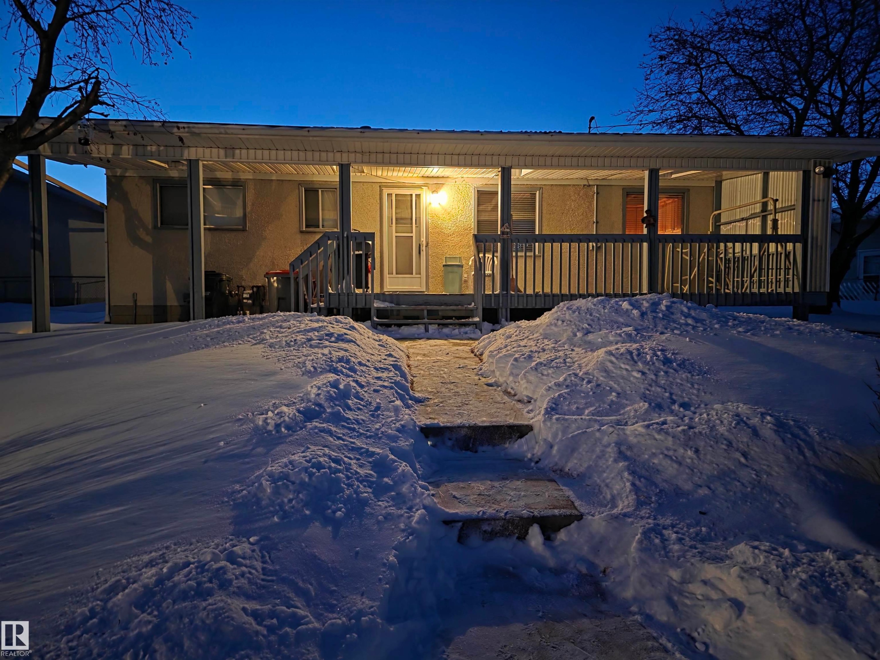 View of front of home with stucco siding and a porch - 4400 45 Avenue, Stony Plain, AB - Outdoor With Deck Patio Veranda