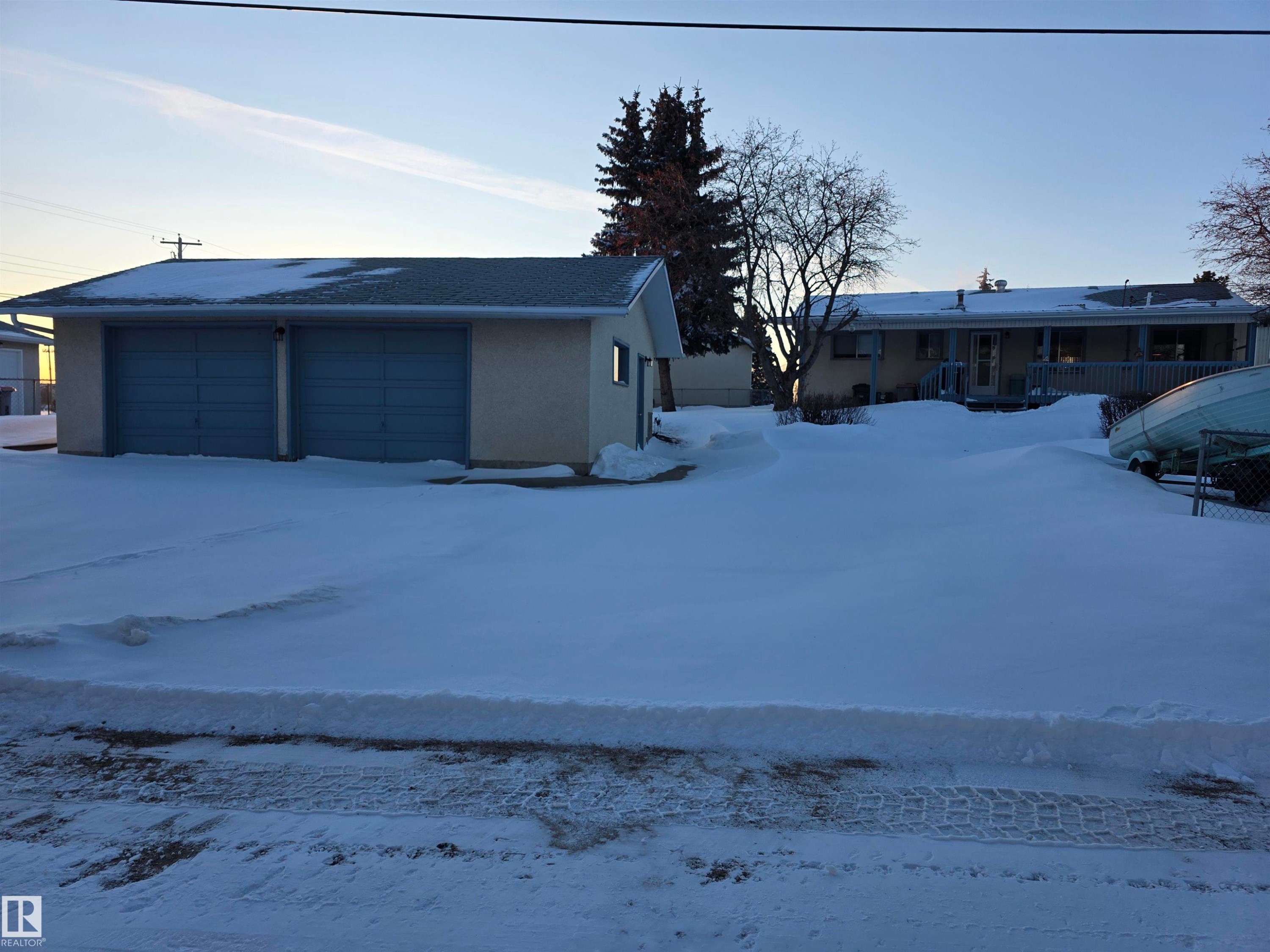 View of front of home with stucco siding and a detached garage - 4400 45 Avenue, Stony Plain, AB - Outdoor