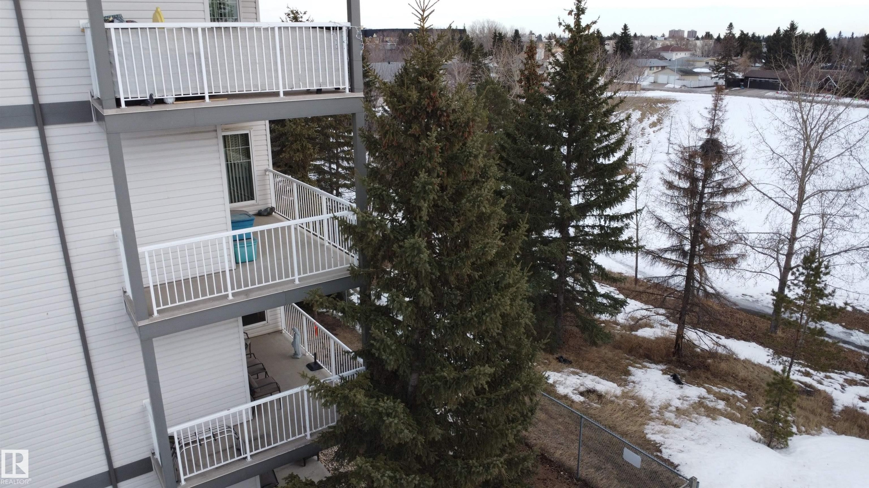 View of snowy exterior featuring a balcony - 227 16807 100 Avenue, Edmonton, AB - Outdoor With Deck Patio Veranda
