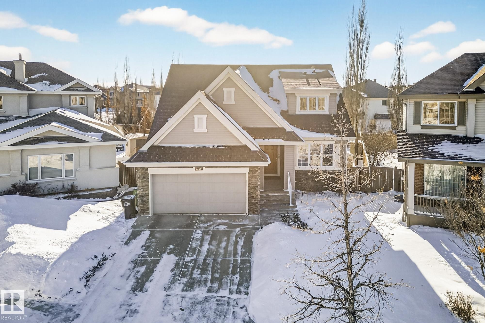 View of front of property with a residential view, stone siding, and driveway - 2036 Hilliard Place, Edmonton, AB - Outdoor With Facade