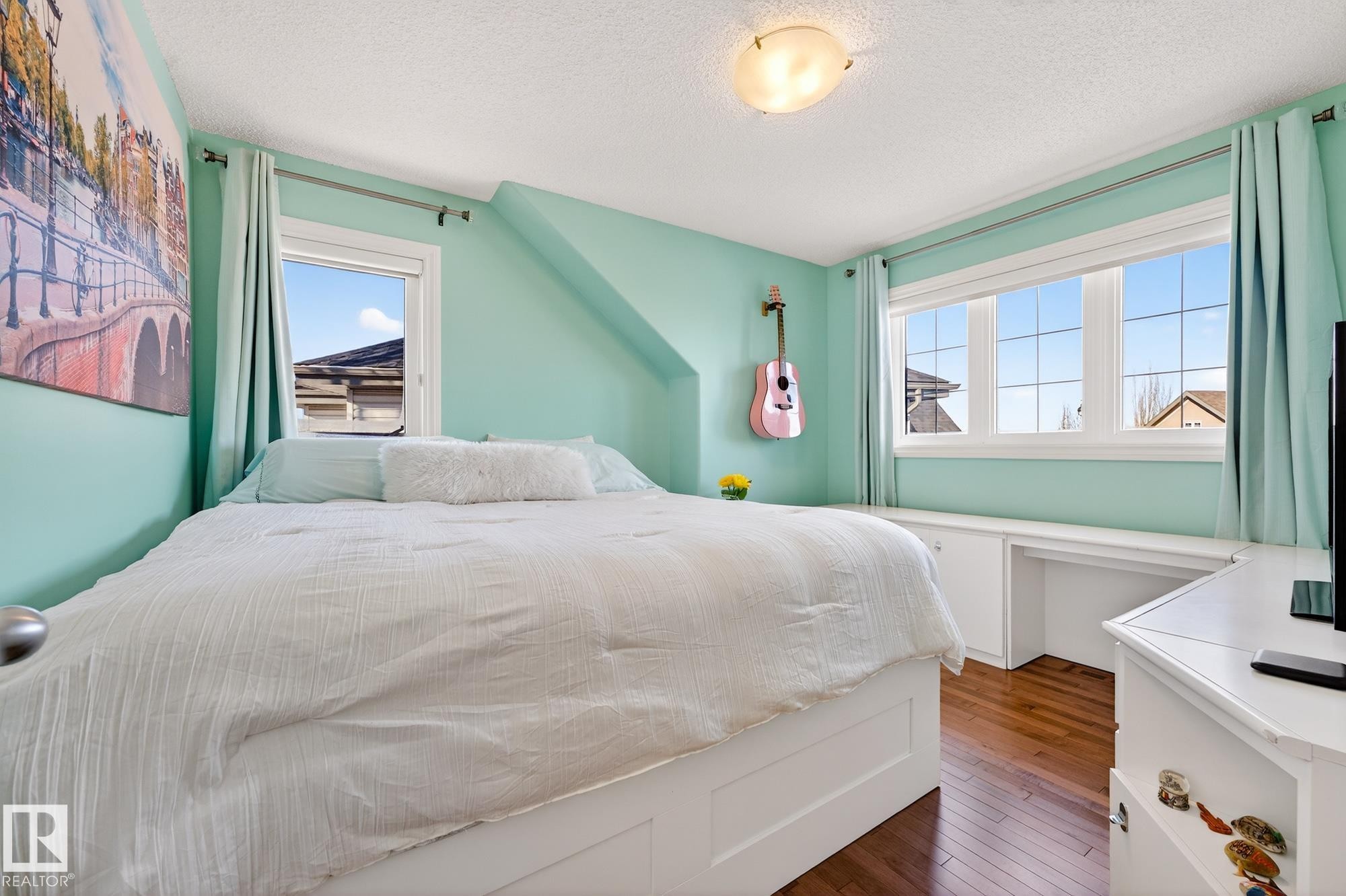 Bedroom featuring dark wood-style flooring, multiple windows, and a textured ceiling - 2036 Hilliard Place, Edmonton, AB - Indoor Photo Showing Bedroom