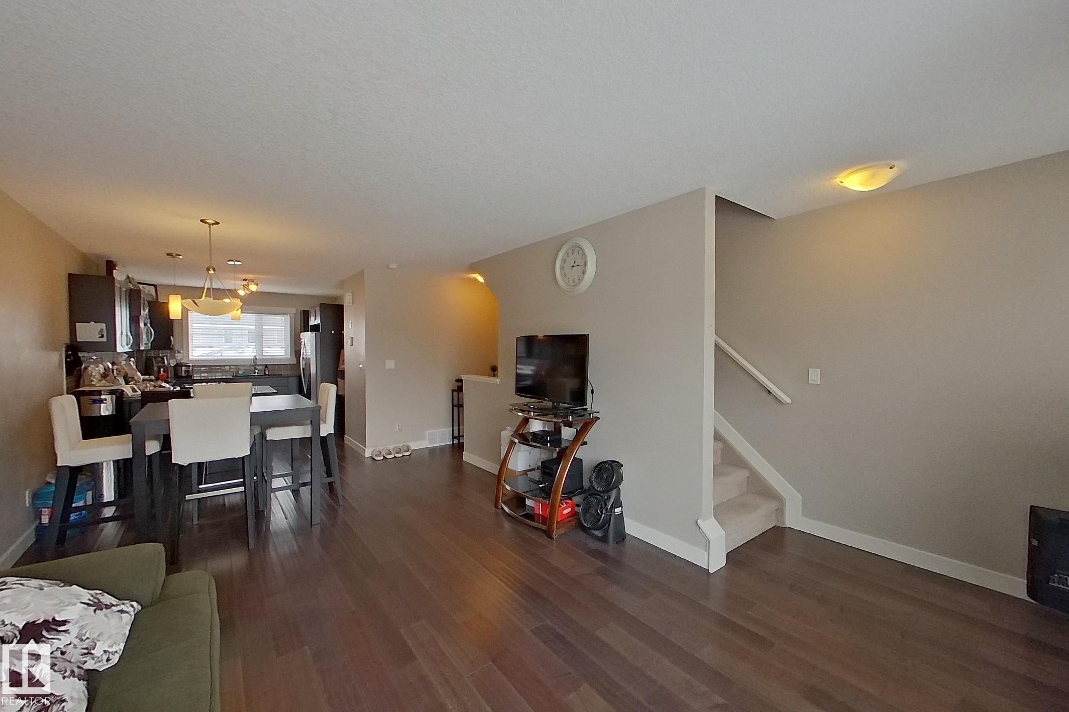 Living area featuring dark wood-style floors and arched walkways - 295 401 Southfork Drive, Leduc, AB - Indoor