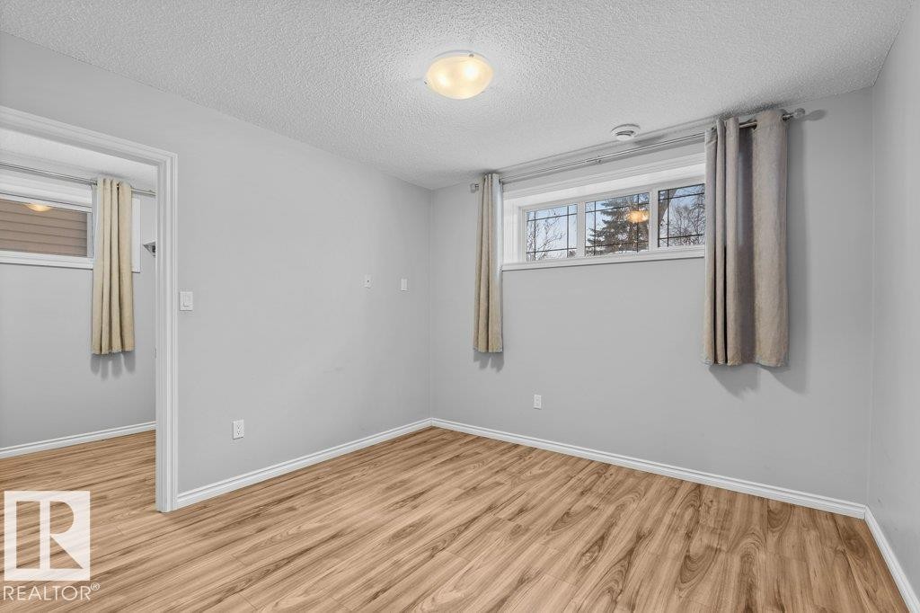 Unfurnished room with a textured ceiling and light wood finished floors - 10639 70 Avenue, Edmonton, AB - Indoor Photo Showing Other Room