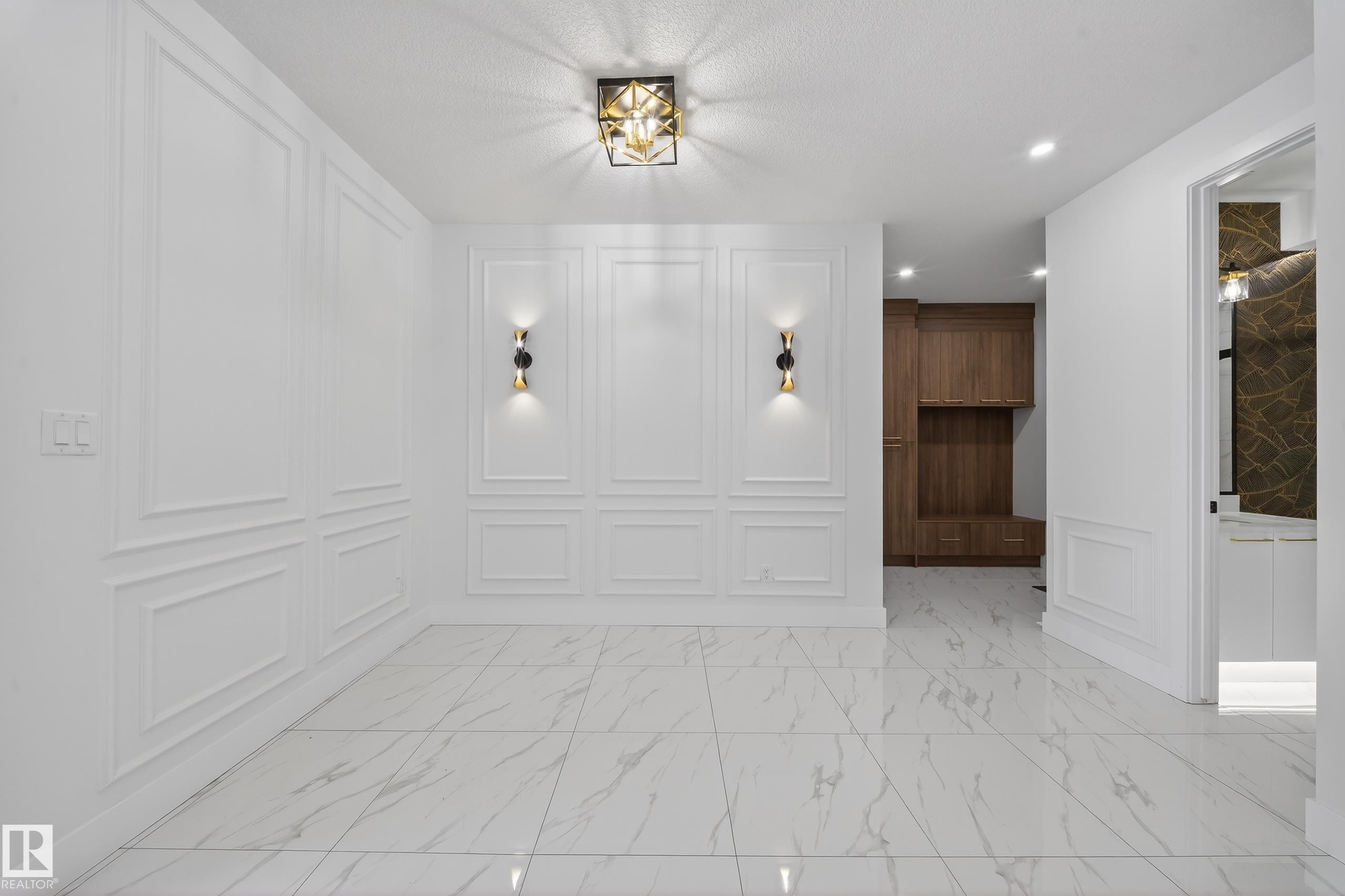 Foyer entrance featuring a decorative wall, light marble finish floors, recessed lighting, and a wainscoted wall - 4006 40 Street, Beaumont, AB - Indoor Photo Showing Other Room