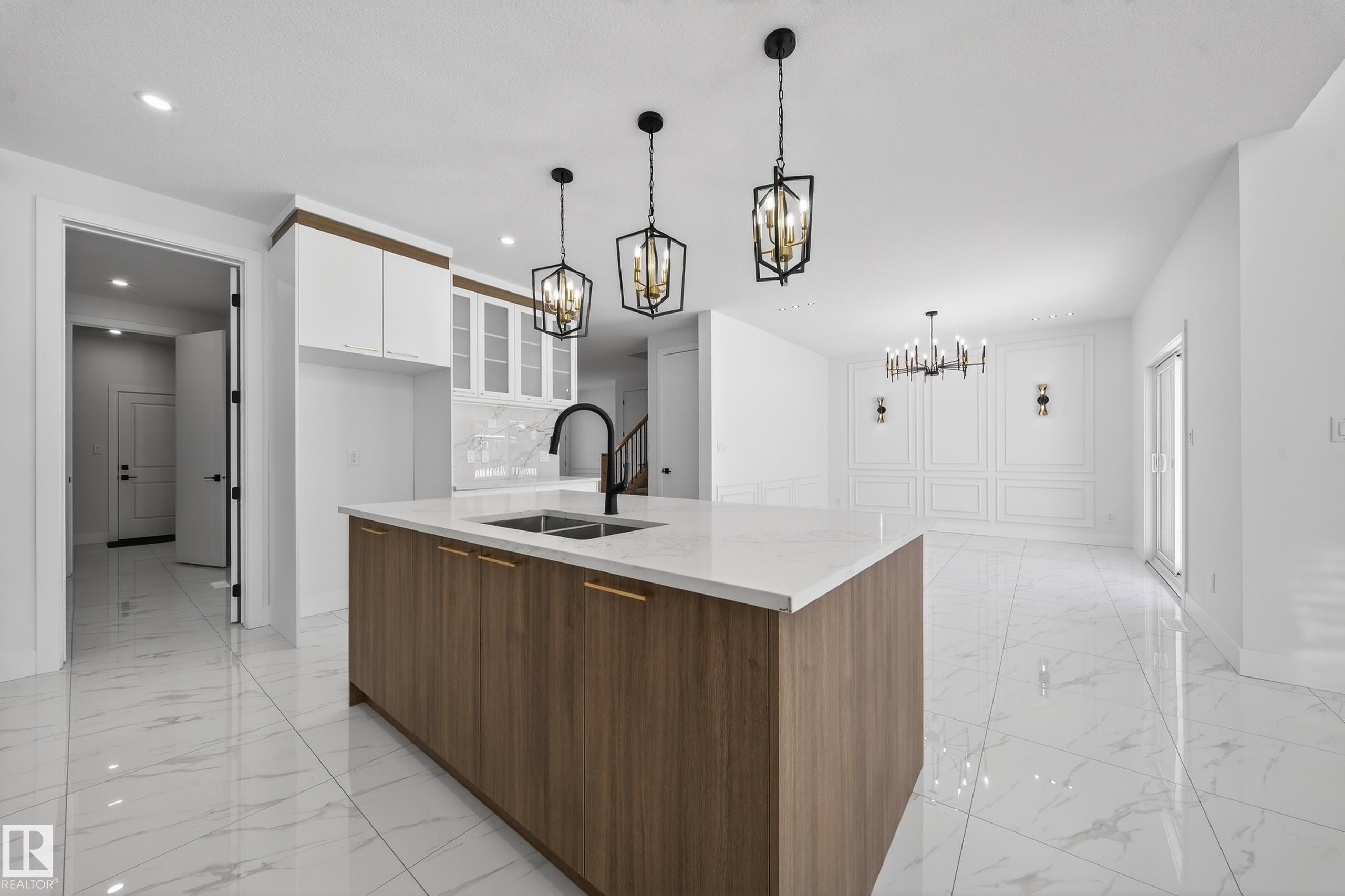 Kitchen with two tone color scheme, glass insert cabinets, modern cabinets, an island with sink, and light stone countertops - 4006 40 Street, Beaumont, AB - Indoor Photo Showing Kitchen With Double Sink