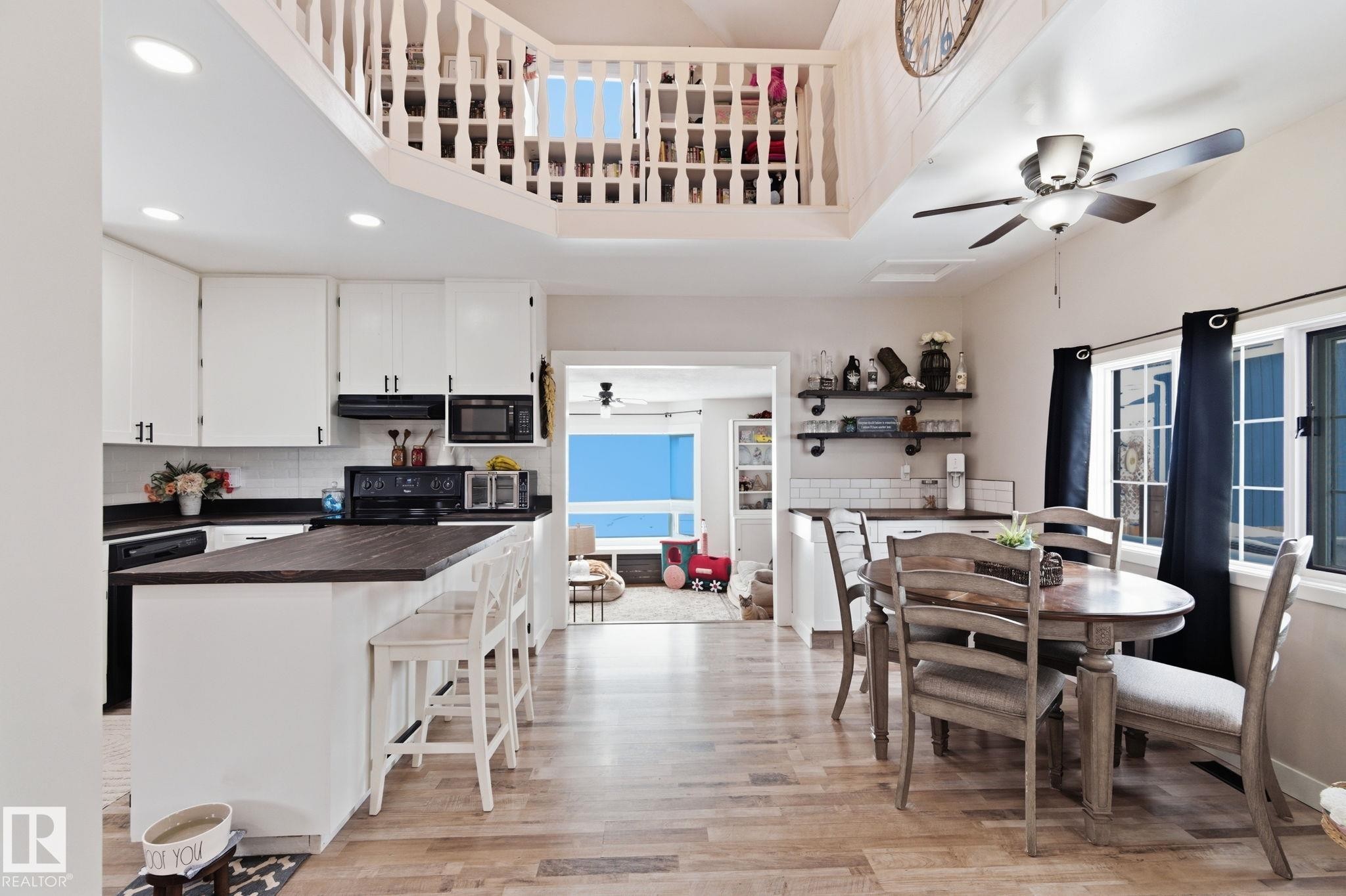 Dining room with ceiling fan, light wood-style flooring, healthy amount of natural light, recessed lighting, and a high ceiling - 4919 50 Avenue, Bon Accord, AB - Indoor Photo Showing Dining Room