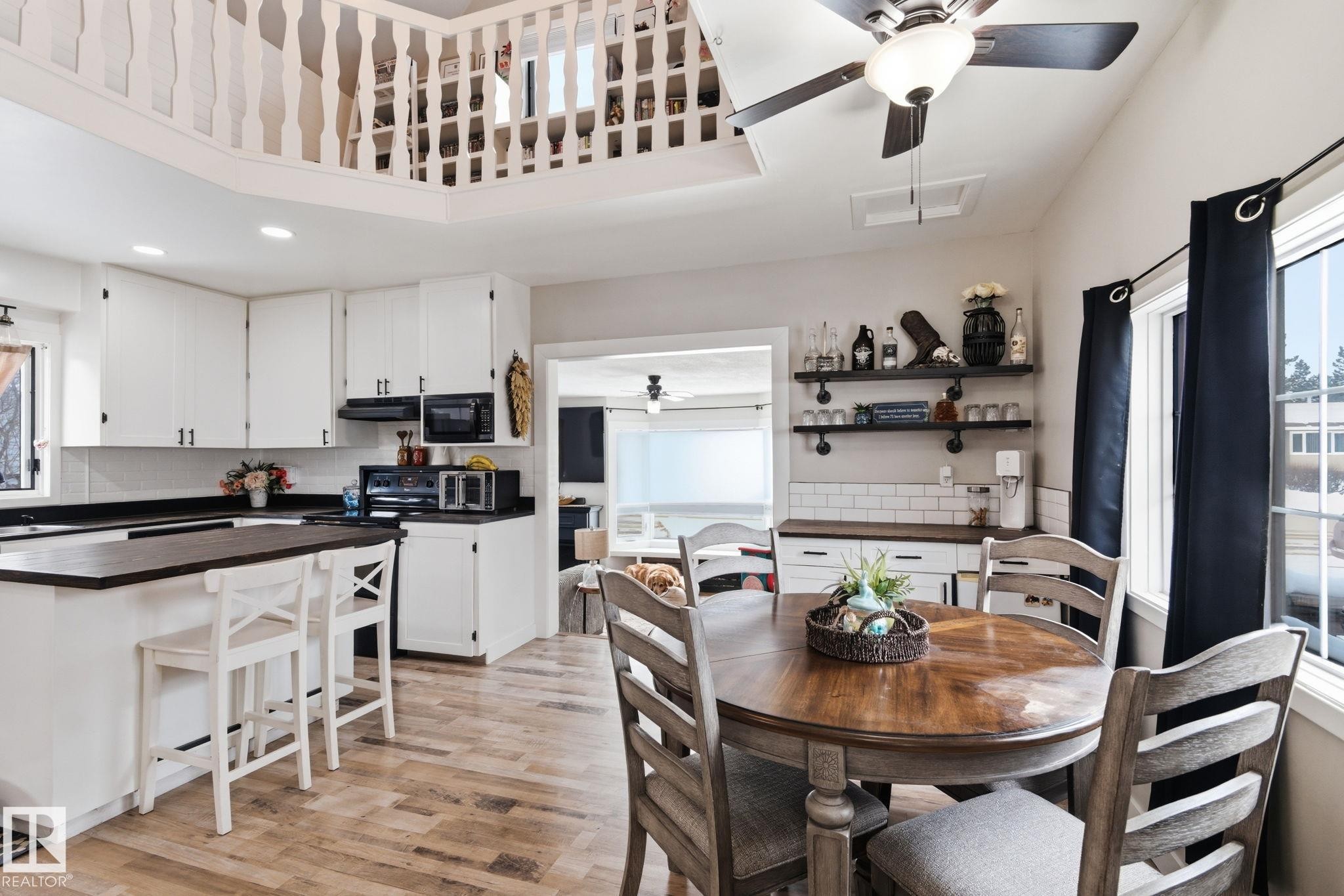 Dining space with a ceiling fan, light wood-style flooring, recessed lighting, and a high ceiling - 4919 50 Avenue, Bon Accord, AB - Indoor Photo Showing Other Room
