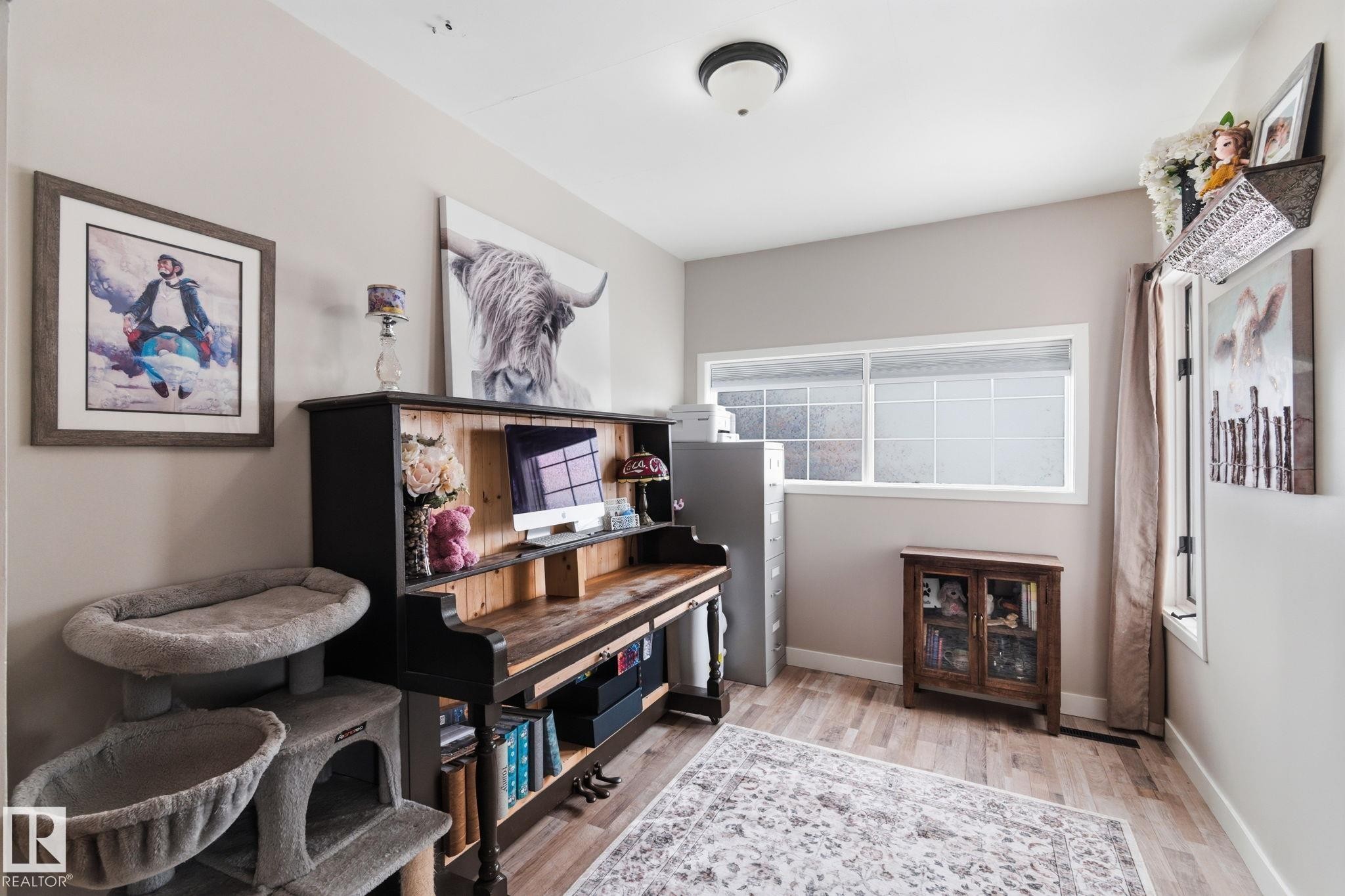 Living area with light wood-style floors and baseboards - 4919 50 Avenue, Bon Accord, AB - Indoor Photo Showing Other Room