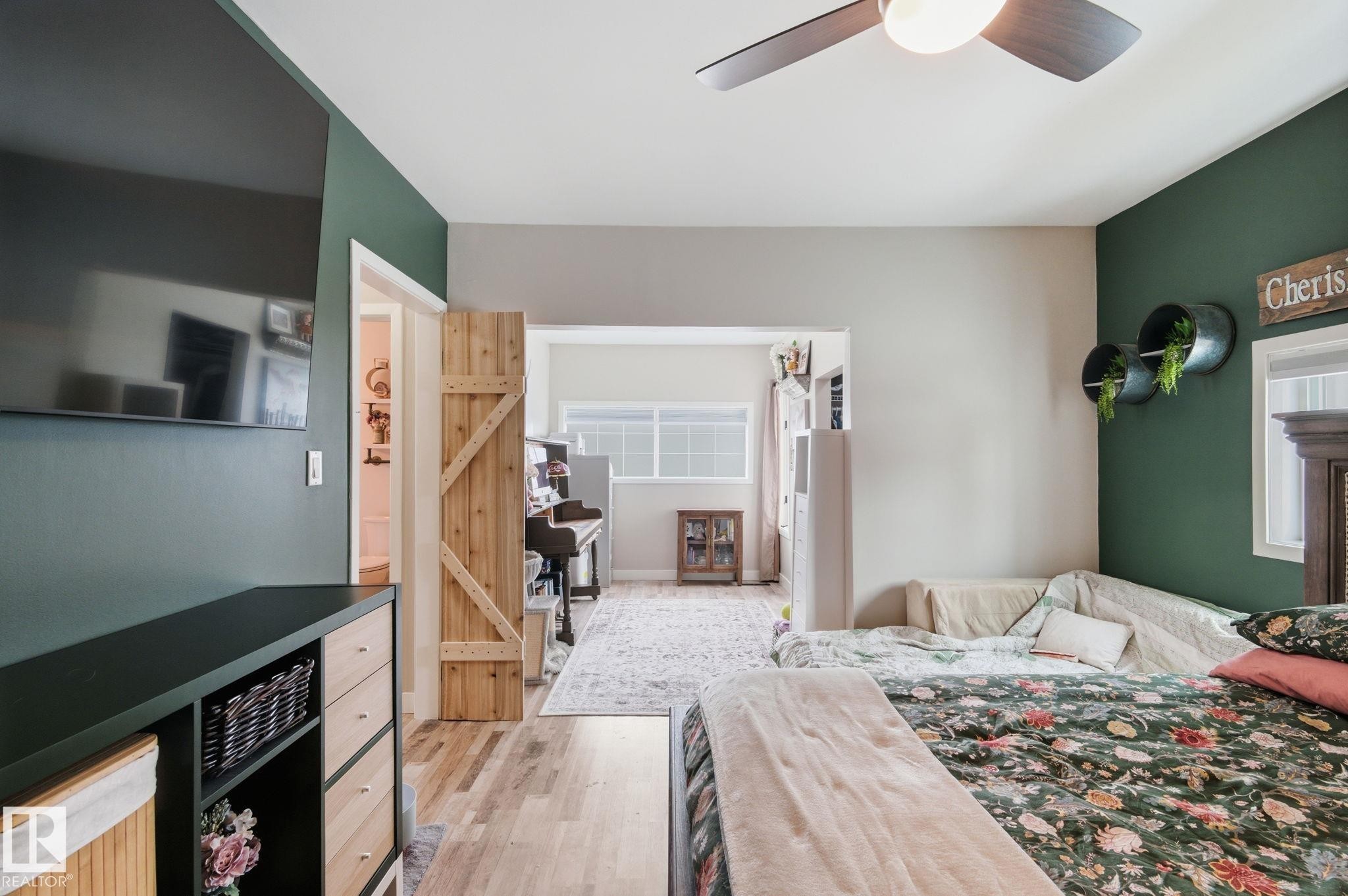 Bedroom with light wood-type flooring and a ceiling fan - 4919 50 Avenue, Bon Accord, AB - Indoor Photo Showing Bedroom