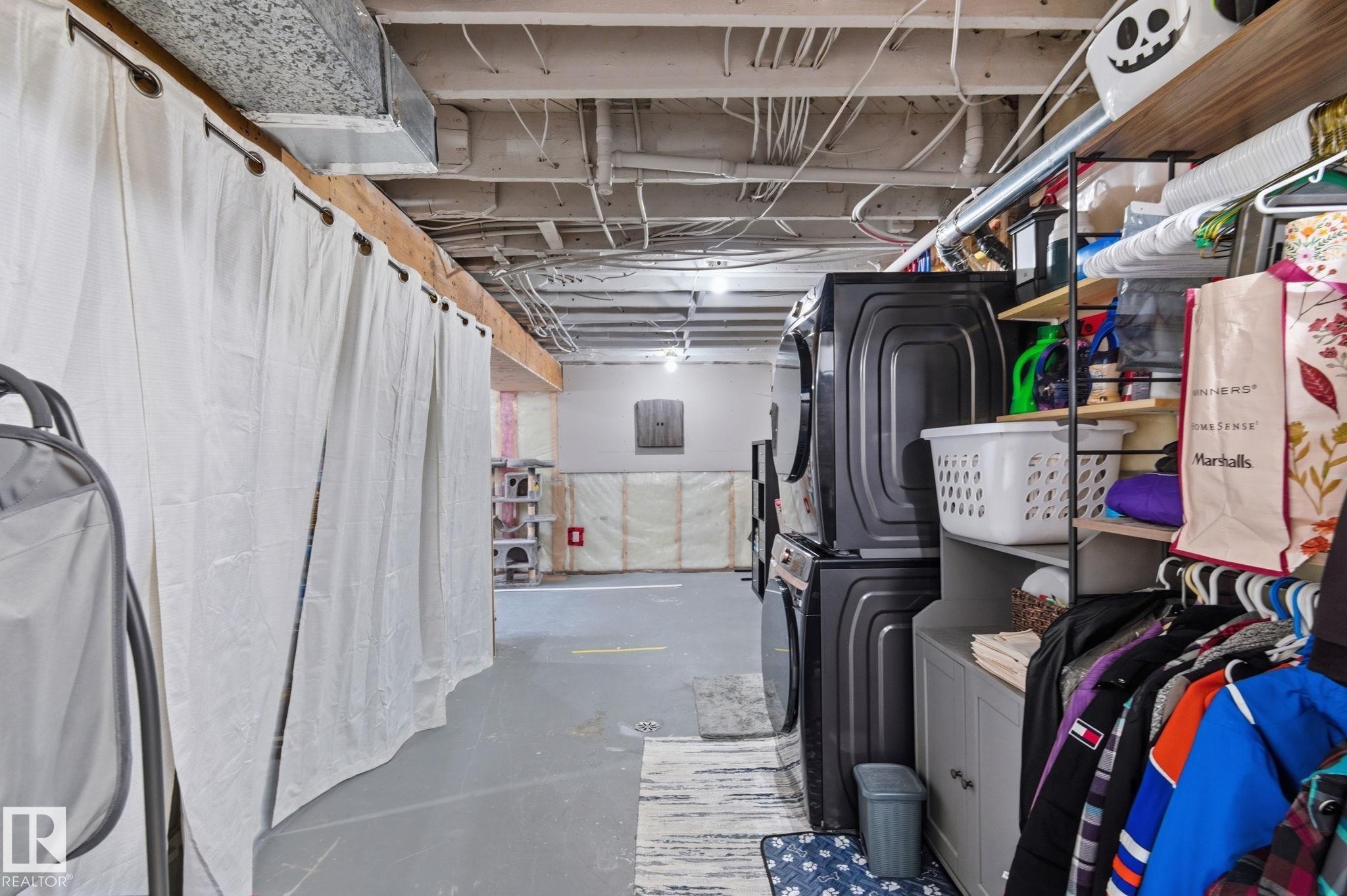 Unfinished below grade area featuring stacked washer / drying machine - 4919 50 Avenue, Bon Accord, AB - Indoor