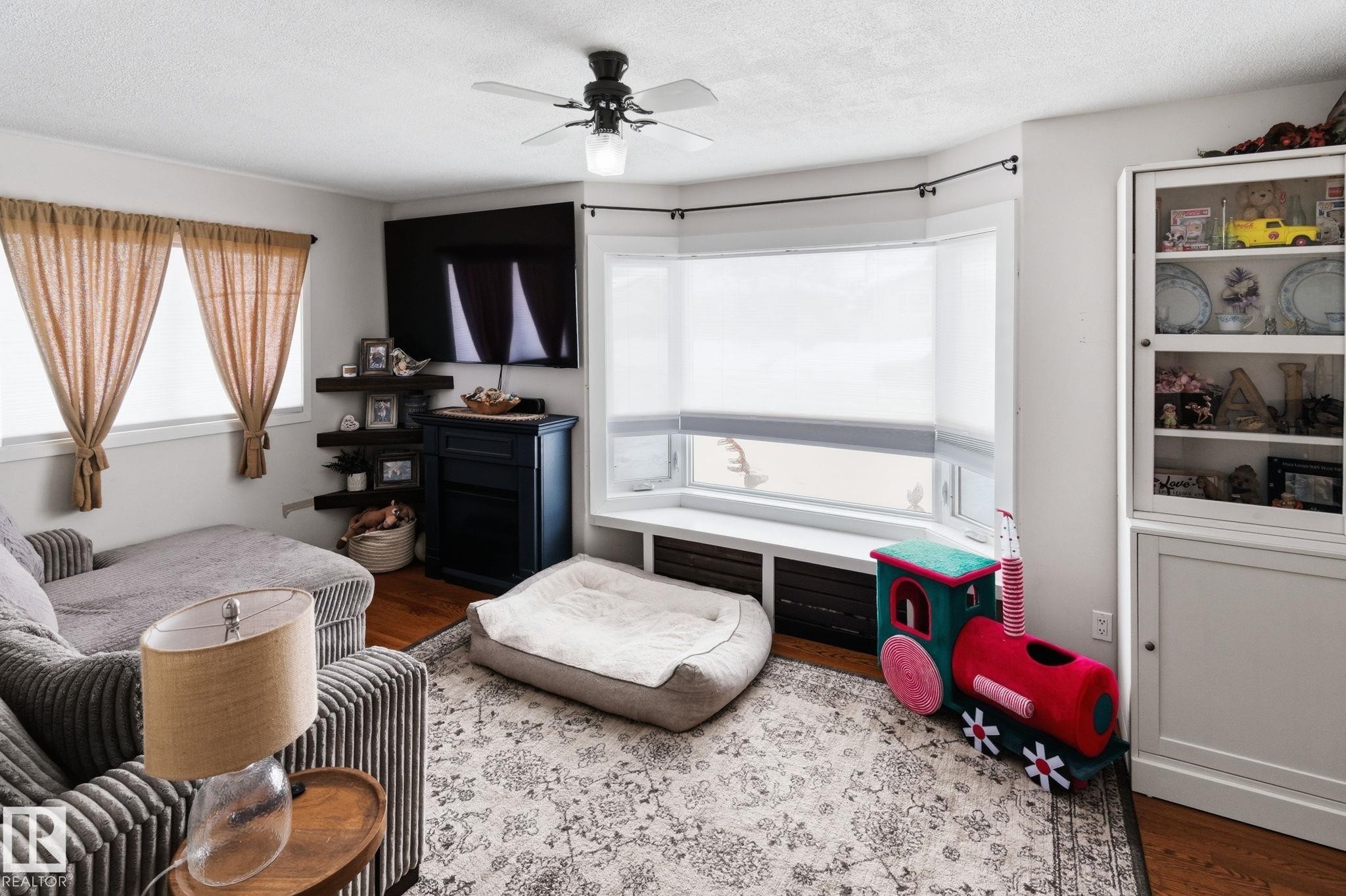 Bedroom featuring wood finished floors, a textured ceiling, and ceiling fan - 4919 50 Avenue, Bon Accord, AB - Indoor