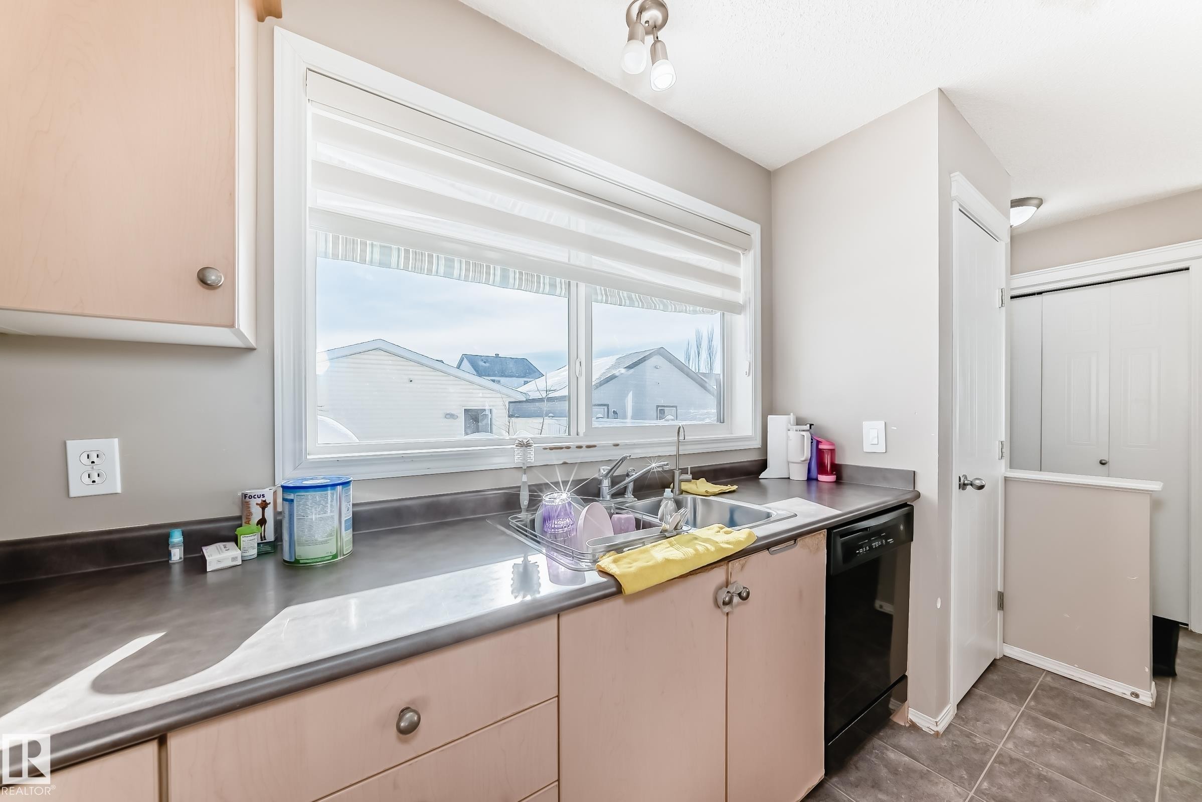 Kitchen featuring dishwasher, light wood finish cabinetry, and dark countertops - 14043 151 Avenue, Edmonton, AB - Indoor Photo Showing Kitchen