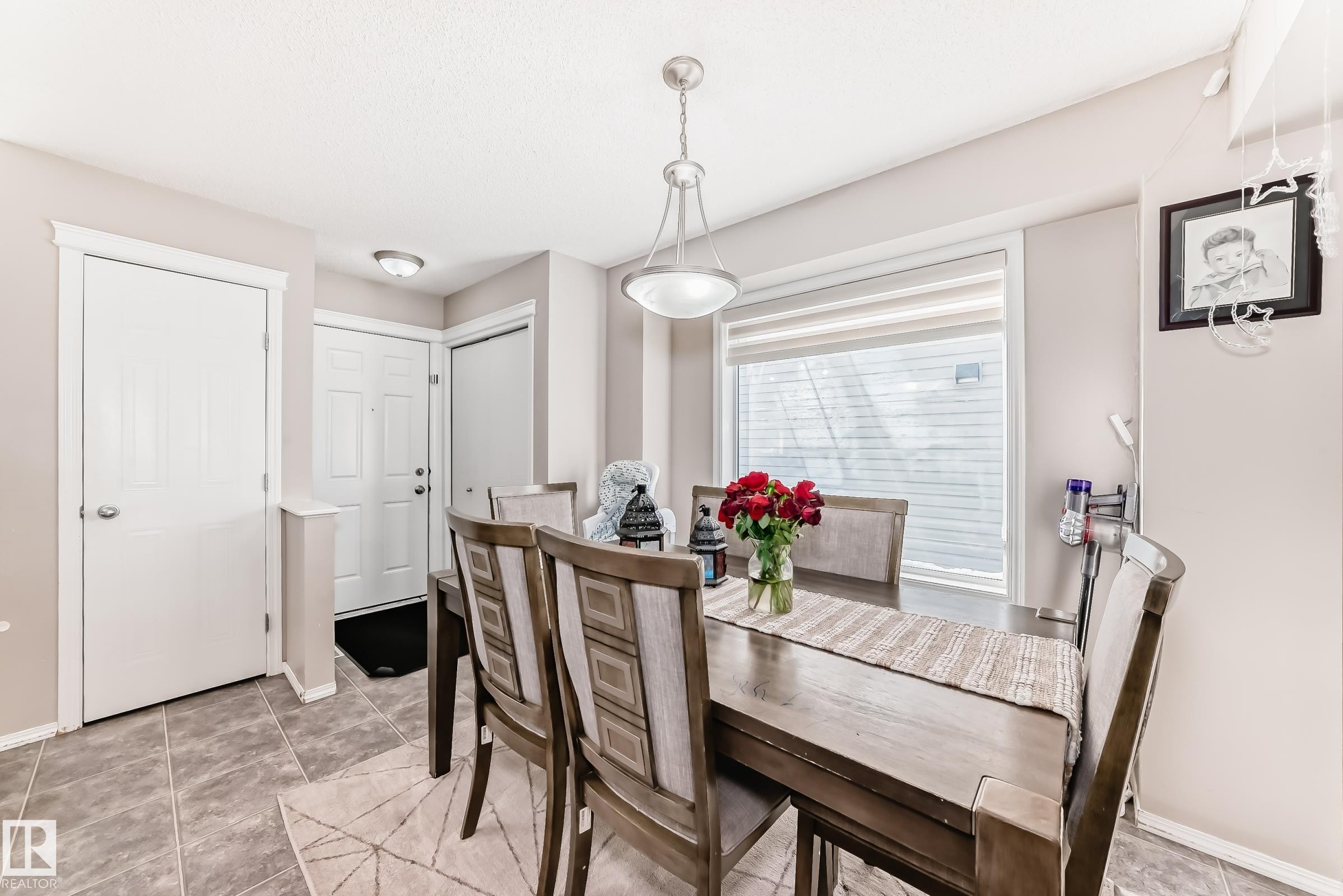 Dining space with baseboards and light tile patterned floors - 14043 151 Avenue, Edmonton, AB - Indoor Photo Showing Dining Room