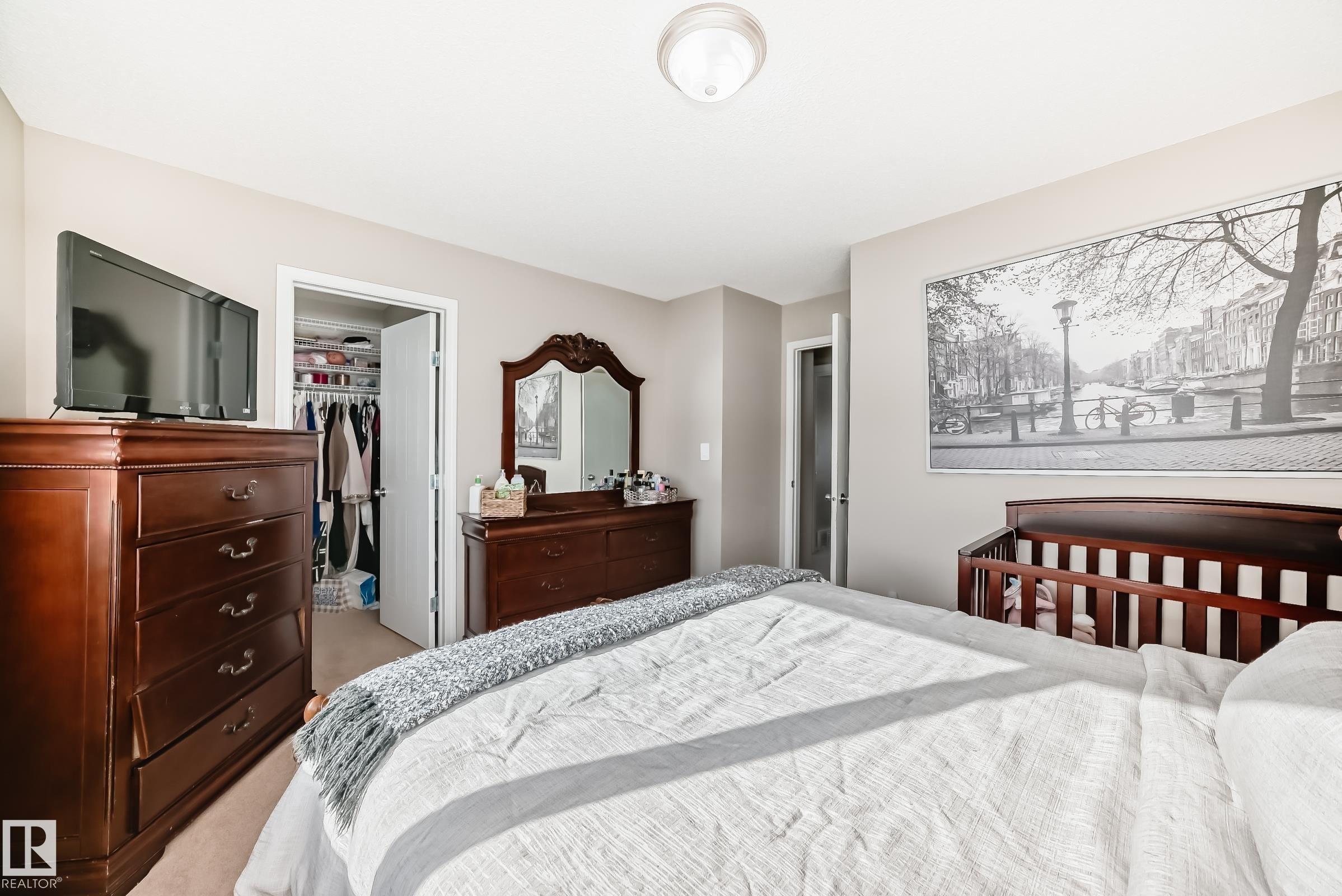 Carpeted bedroom featuring a walk in closet - 14043 151 Avenue, Edmonton, AB - Indoor Photo Showing Bedroom