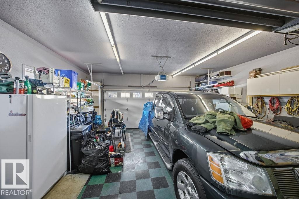 Garage featuring freestanding refrigerator and a garage door opener - 3011 44A Street, Edmonton, AB - Indoor Photo Showing Garage