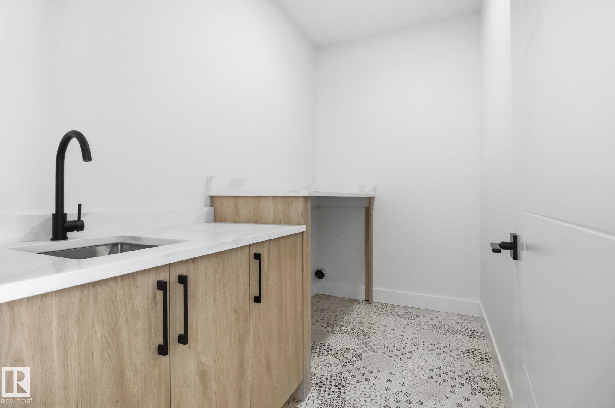 Laundry room featuring a sink and light tile patterned floors - 90 Eldridge Point(E), St. Albert, AB - Indoor