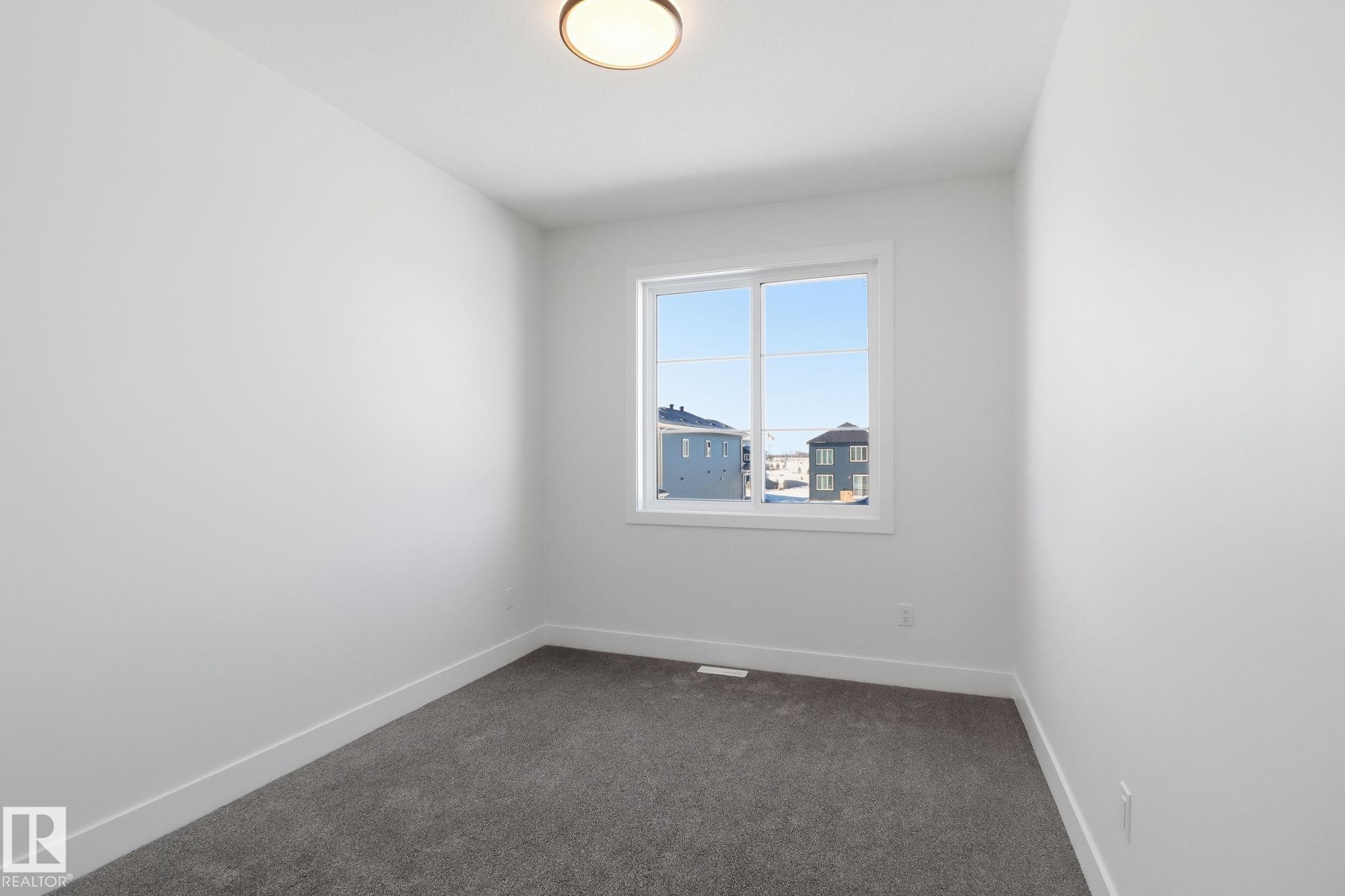 Unfurnished room featuring dark colored carpet and baseboards - 90 Eldridge Point(E), St. Albert, AB - Indoor Photo Showing Other Room