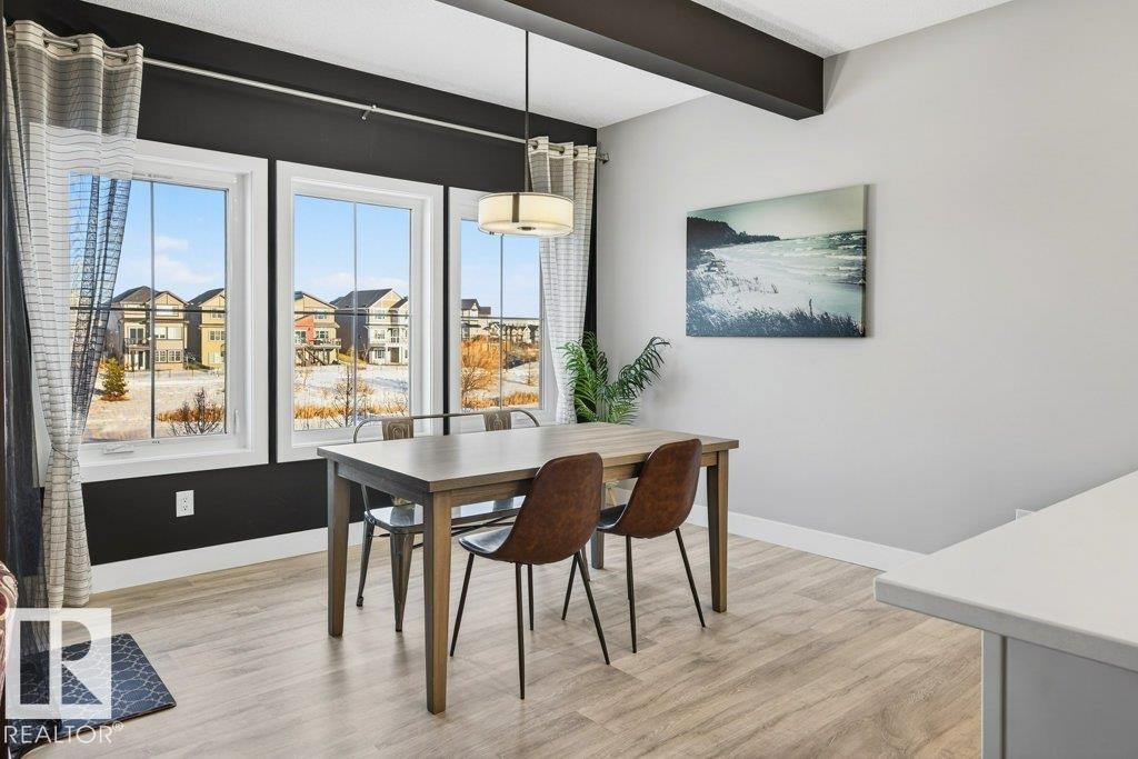 Kitchen nook/dining area with dark feature wall filled with large bright windows overlooking a breathtaking pond view. - 1909 Davidson Wynd, Edmonton, AB - Indoor Photo Showing Dining Room