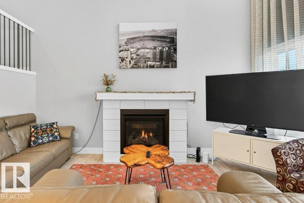 Open-to-below great room flanked by huge windows looking out over the deck and to the pond + the vast open staircase leading to the second floor. - 1909 Davidson Wynd, Edmonton, AB - Indoor Photo Showing Living Room With Fireplace