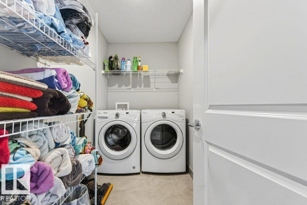 Laundry room with tiled floors and plenty of storage space. - 1909 Davidson Wynd, Edmonton, AB - Indoor Photo Showing Laundry Room