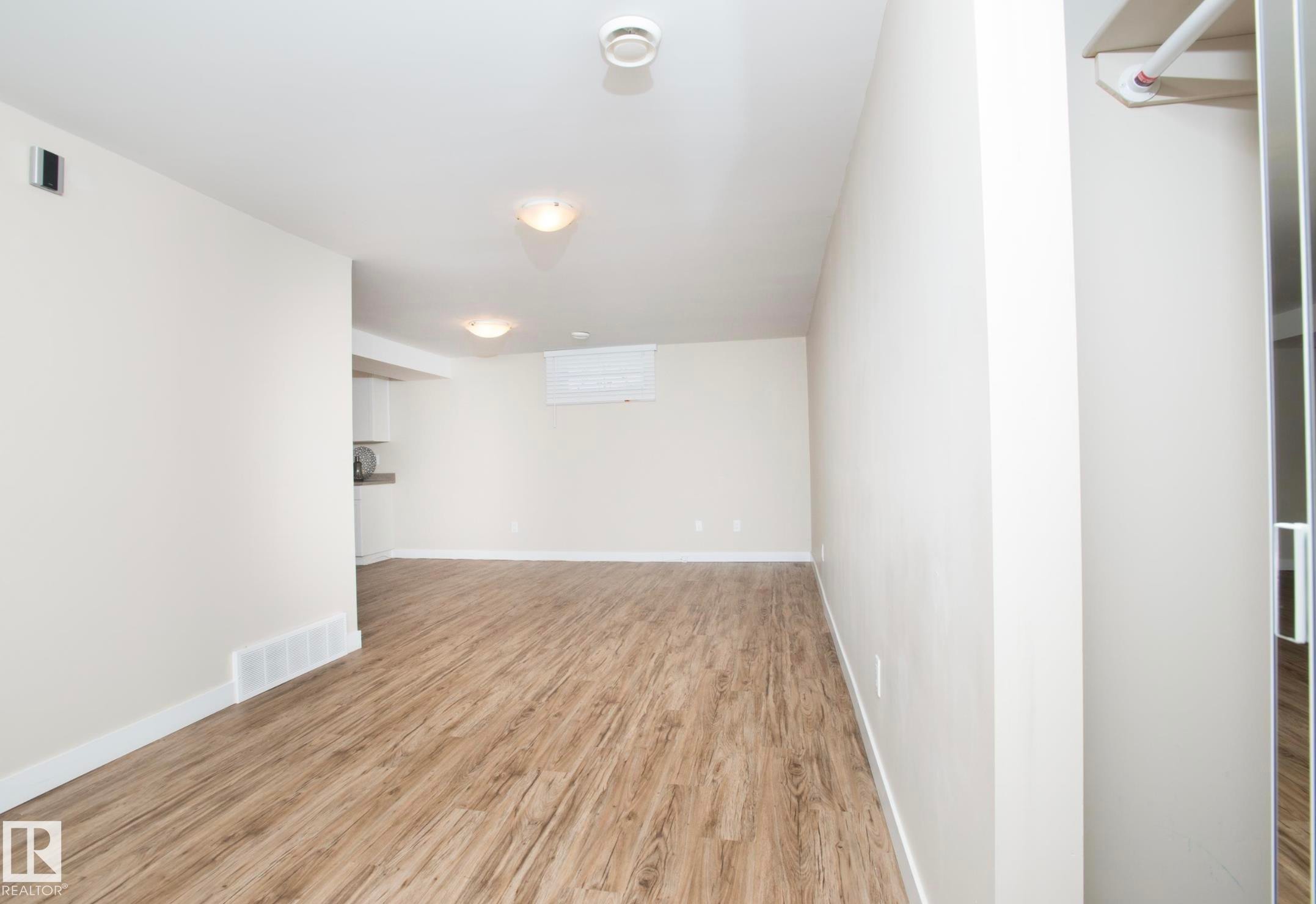 Unfurnished room featuring light wood-style flooring and baseboards - 13616 82 Street Nw, Edmonton, AB - Indoor Photo Showing Other Room