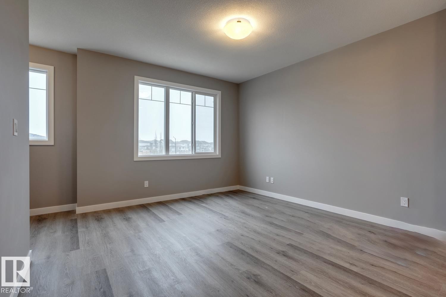 Unfurnished room featuring baseboards and light wood finished floors - 78 13139 205 Street Nw, Edmonton, AB - Indoor Photo Showing Other Room
