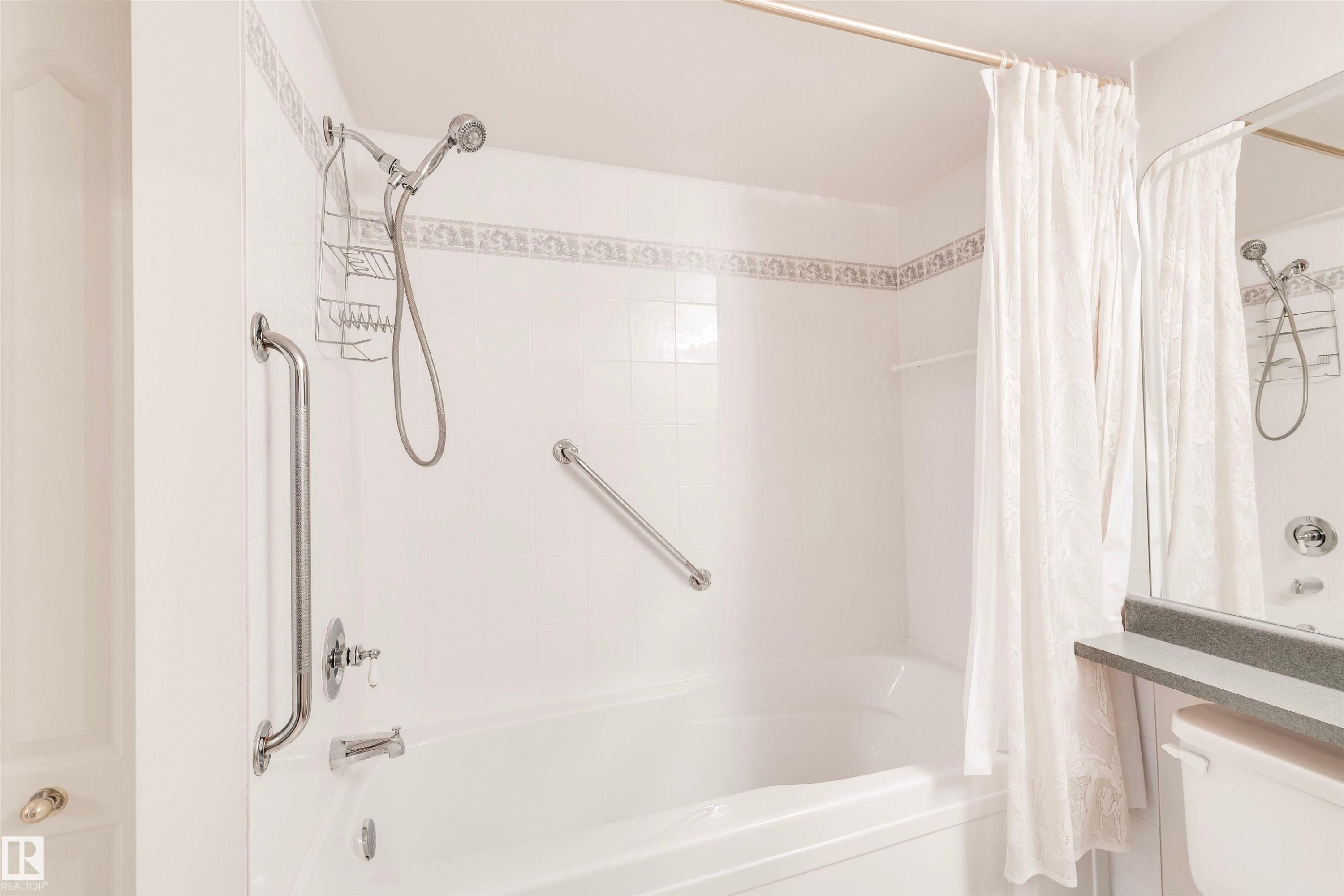 Bathroom featuring shower / tub combo with curtain and toilet - 209 17150 94A Avenue, Edmonton, AB - Indoor Photo Showing Bathroom