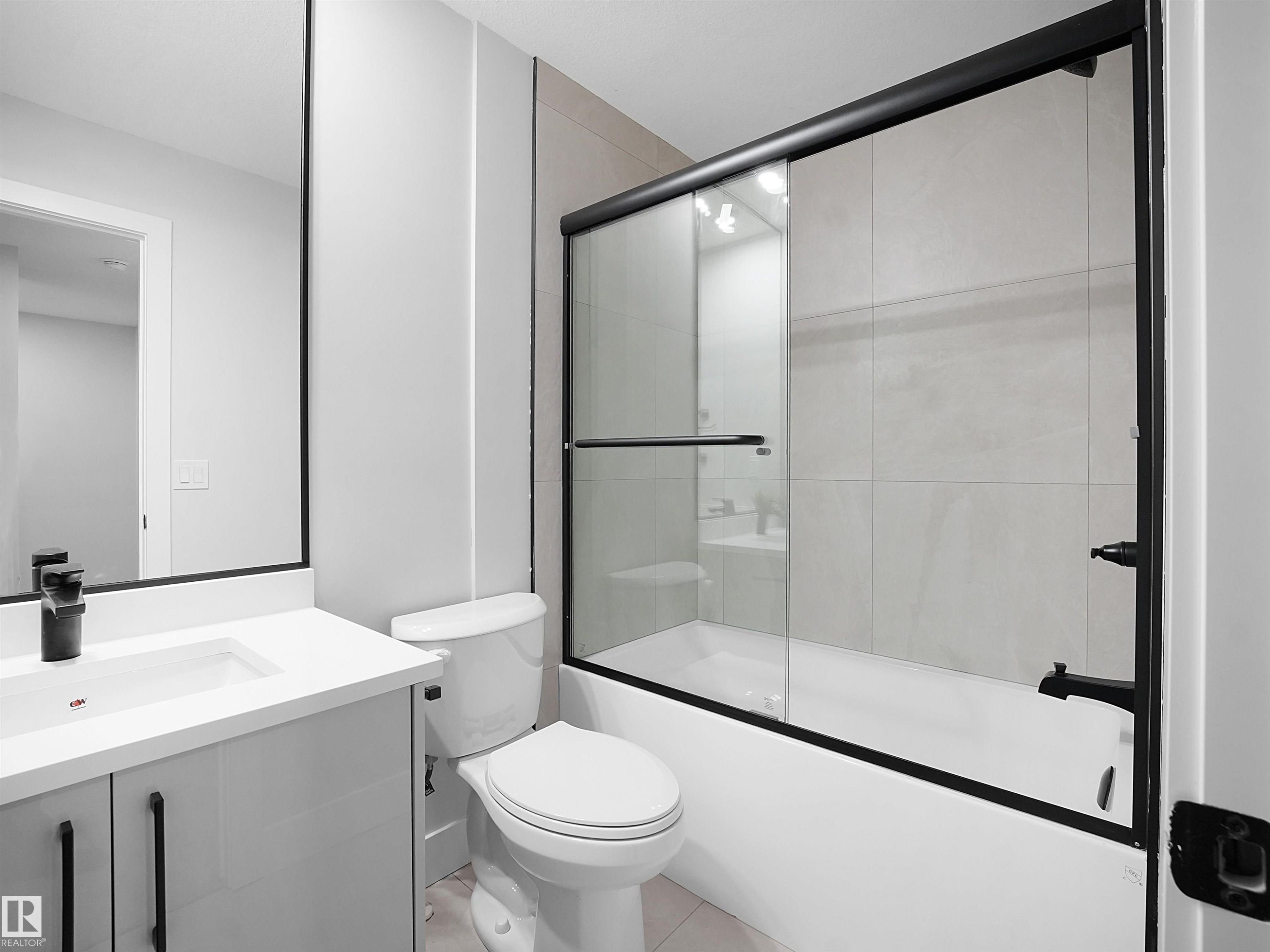 Bathroom featuring vanity, combined bath / shower with glass door, and tile patterned floors - 9409 173 Street, Edmonton, AB - Indoor Photo Showing Bathroom