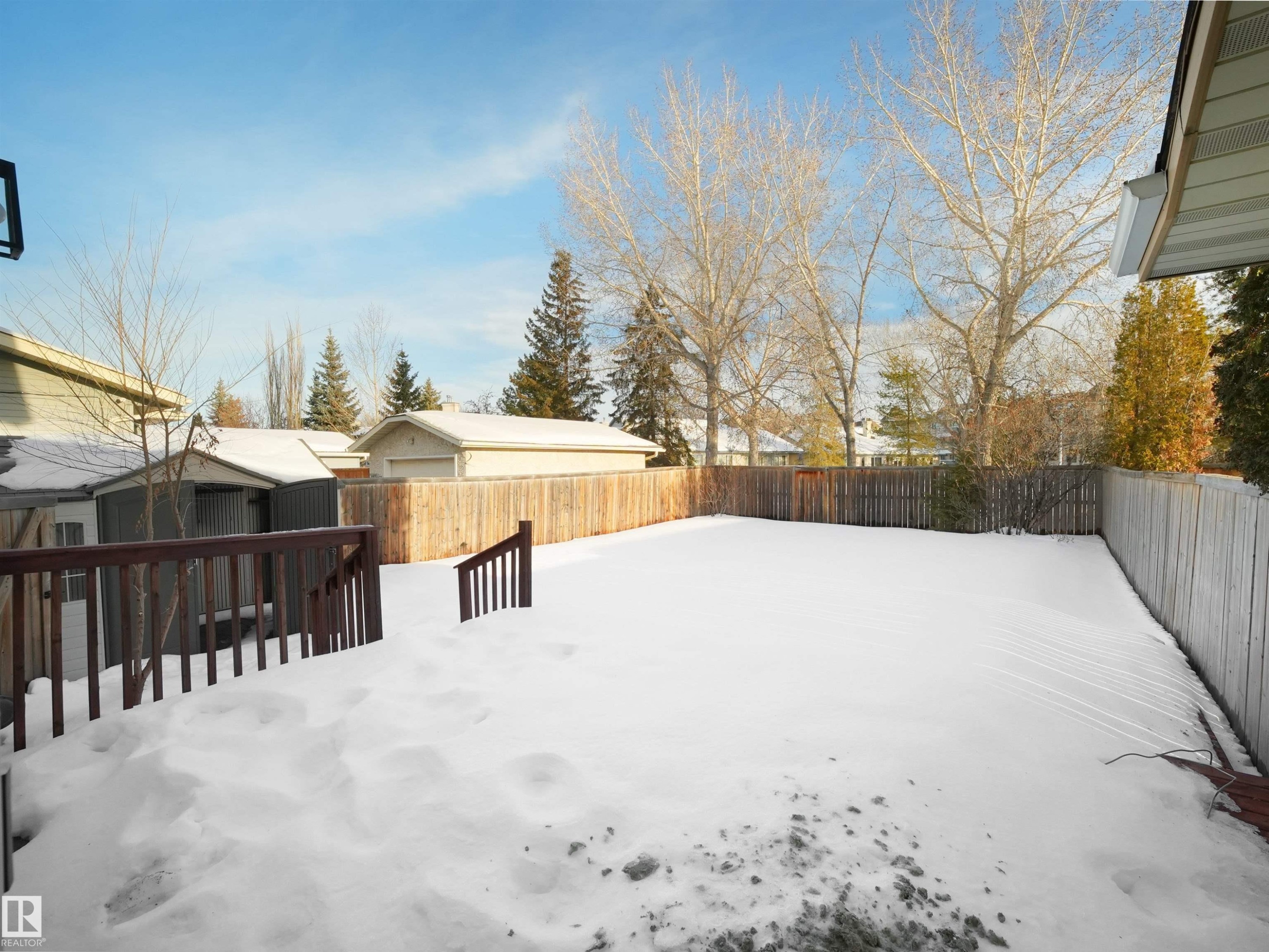 Yard layered in snow featuring a shed, a deck, and a fenced backyard - 9409 173 Street, Edmonton, AB - Outdoor