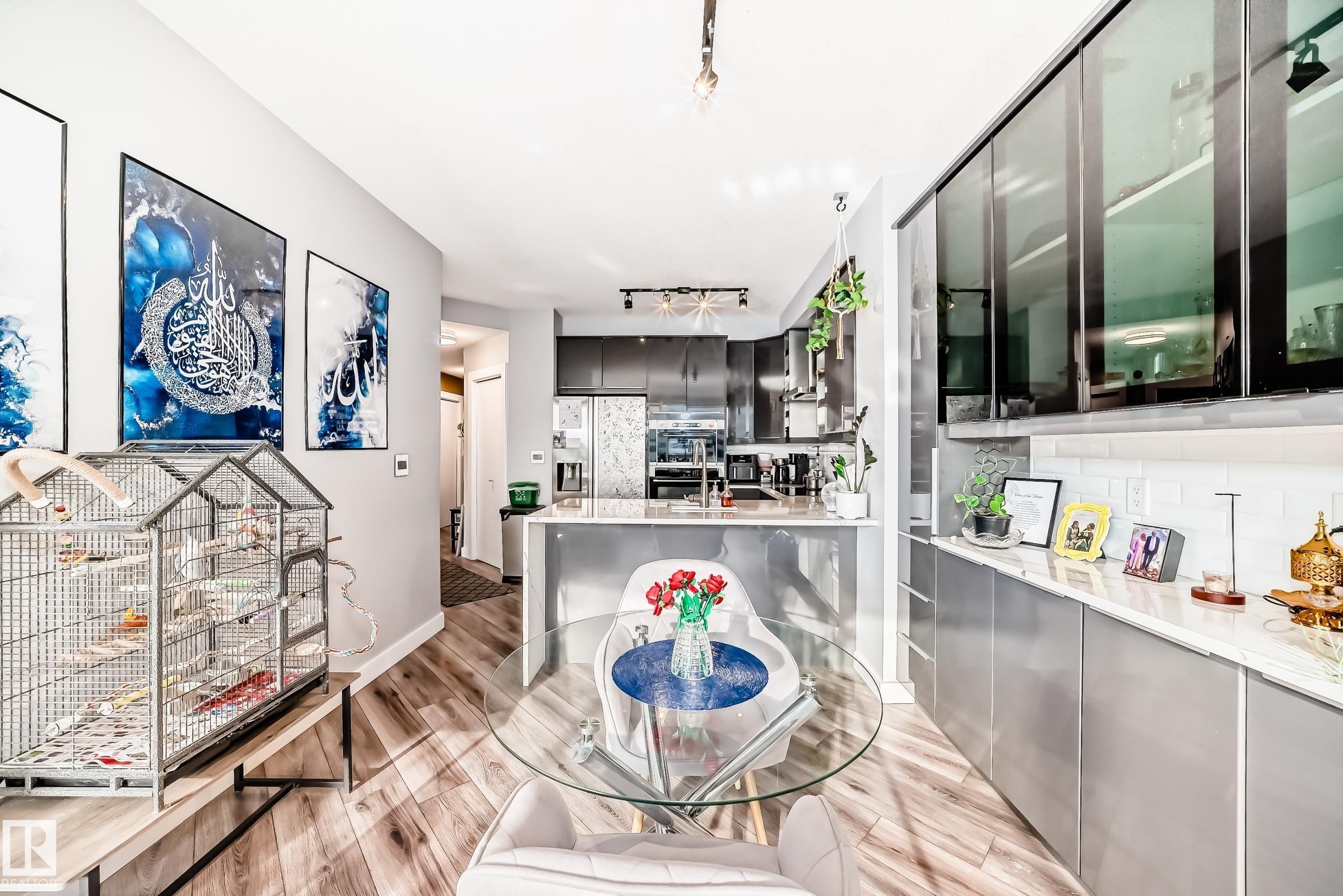 Kitchen featuring a peninsula, stainless steel fridge with ice dispenser, tasteful backsplash, light wood-style flooring, and modern cabinets - 2004 10136 104 Street, Edmonton, AB - Indoor