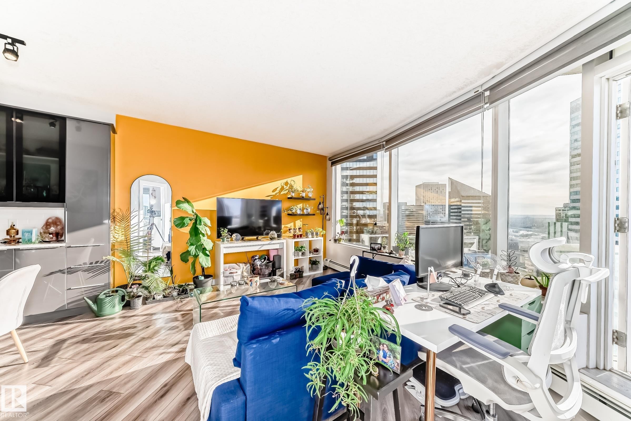 Living area with a baseboard radiator, wood finished floors, and an office area - 2004 10136 104 Street, Edmonton, AB - Indoor