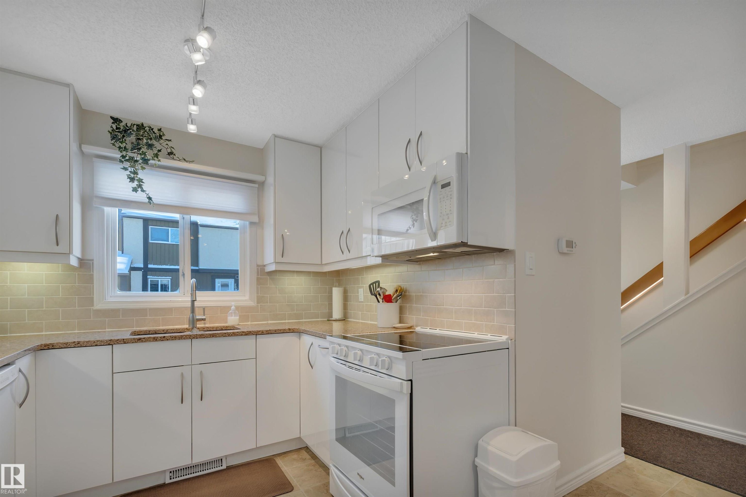 Kitchen featuring white appliances, white cabinetry, light stone countertops, and a textured ceiling - 7075 32 Avenue, Edmonton, AB - Indoor Photo Showing Kitchen