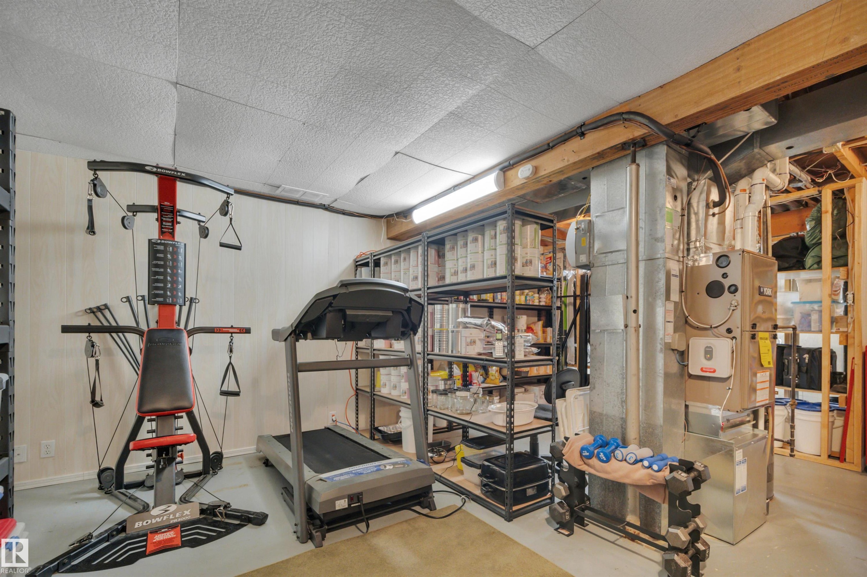 Workout room with finished concrete flooring and heating unit - 7075 32 Avenue, Edmonton, AB - Indoor Photo Showing Gym Room