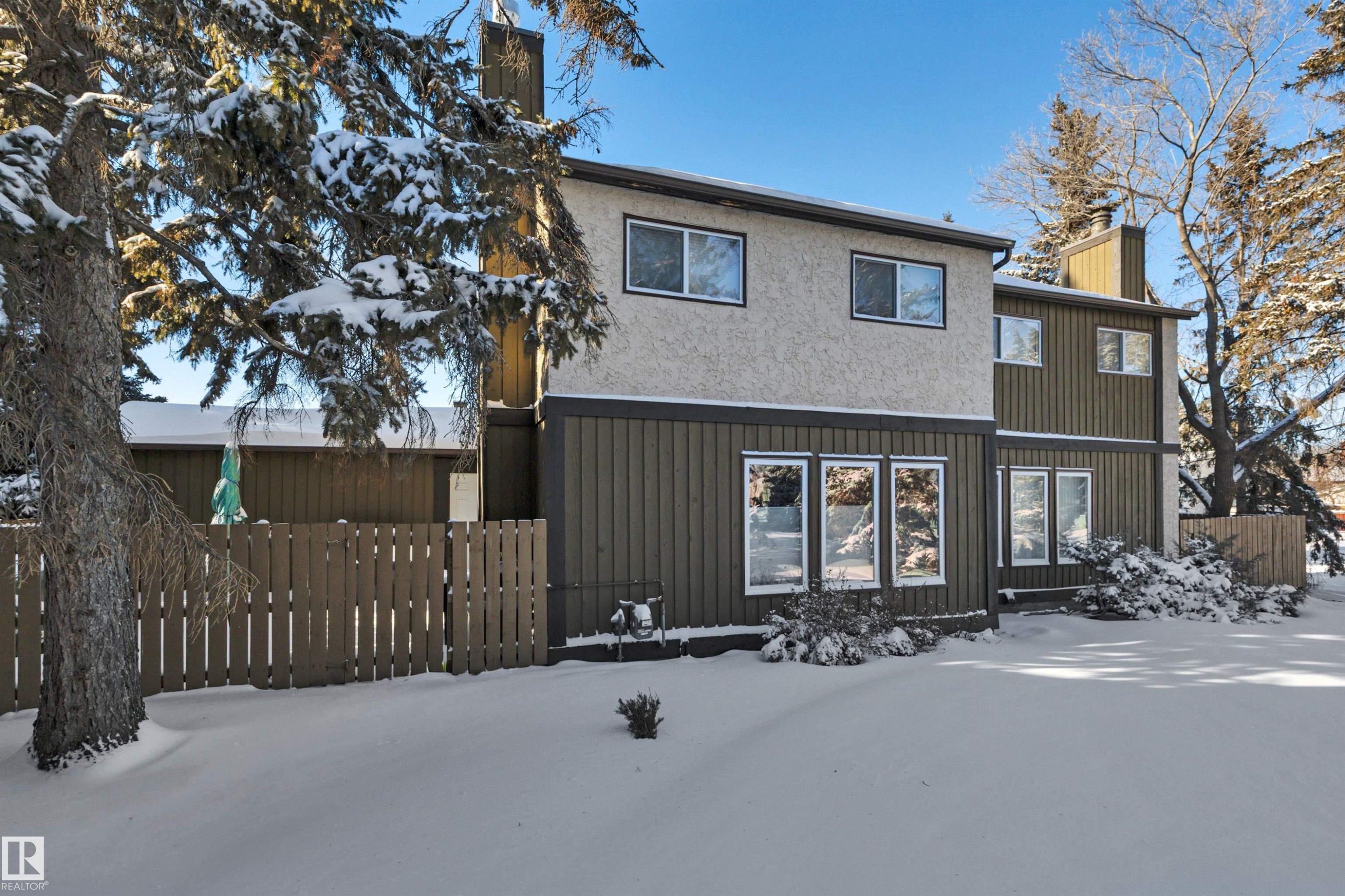 Snow covered property with a chimney and stucco siding - 7075 32 Avenue, Edmonton, AB - Outdoor