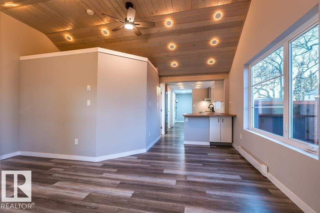 Interior space with ceiling fan, recessed lighting, baseboard heating, dark wood-style flooring, and a vaulted wood ceiling - 4713 48 Avenue, Wetaskiwin, AB - Indoor Photo Showing Other Room