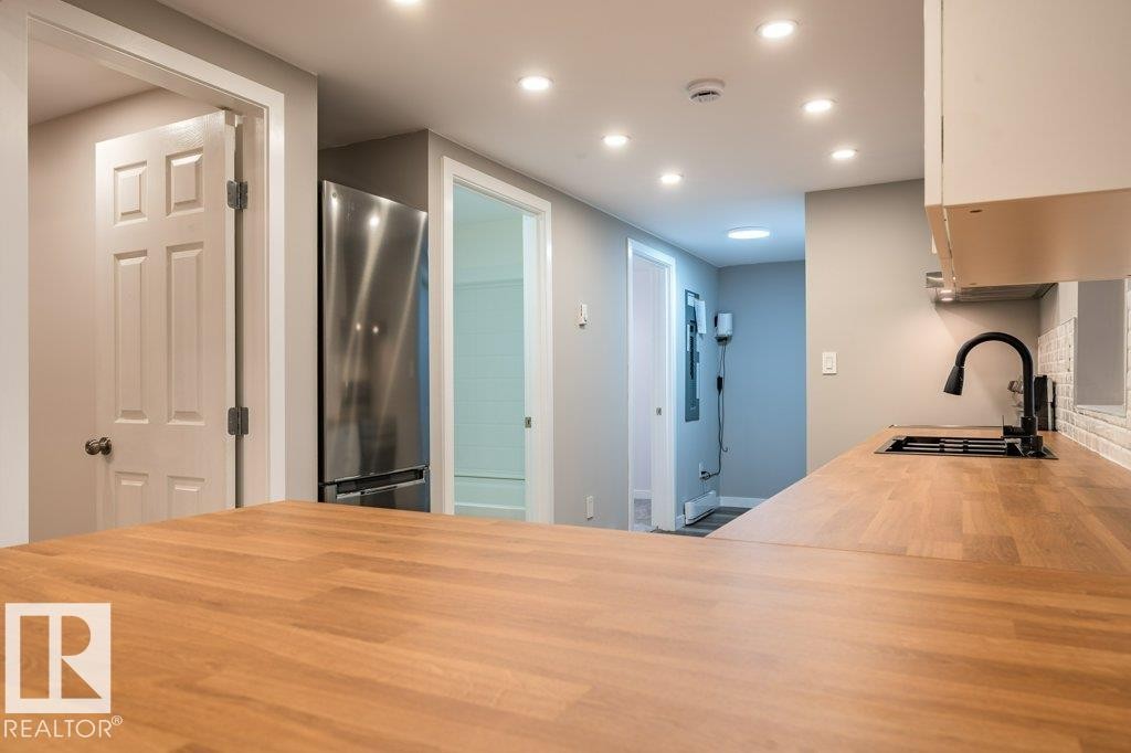 Kitchen featuring butcher block counters, freestanding refrigerator, recessed lighting, and a peninsula - 4713 48 Avenue, Wetaskiwin, AB - Indoor