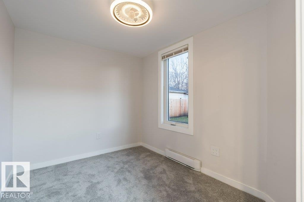 Spare room with carpet and a baseboard radiator - 4713 48 Avenue, Wetaskiwin, AB - Indoor Photo Showing Other Room