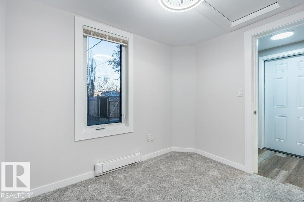 Carpeted spare room with baseboard heating and baseboards - 4713 48 Avenue, Wetaskiwin, AB - Indoor Photo Showing Other Room