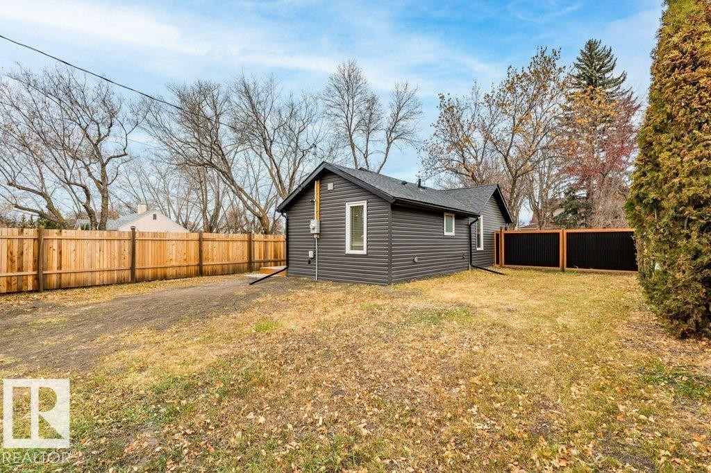 View of property exterior featuring a fenced backyard and faux log siding - 4713 48 Avenue, Wetaskiwin, AB - Outdoor