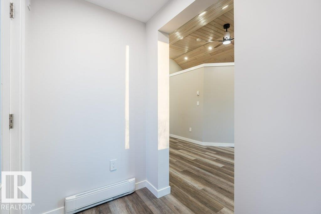 Spare room with baseboard heating, wood finished floors, a ceiling fan, recessed lighting, and a vaulted wood ceiling - 4713 48 Avenue, Wetaskiwin, AB - Indoor Photo Showing Other Room