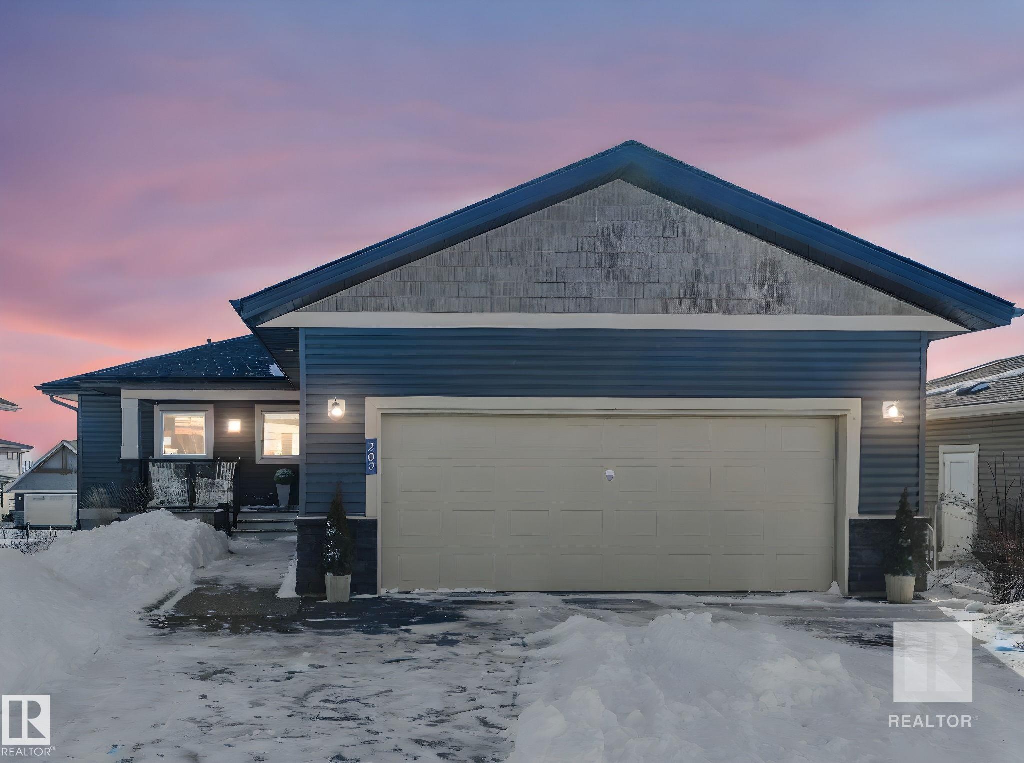 Ranch-style house featuring a garage and driveway - 209 55101 Ste. Anne Trail, Rural Lac Ste. Anne County, AB - Outdoor