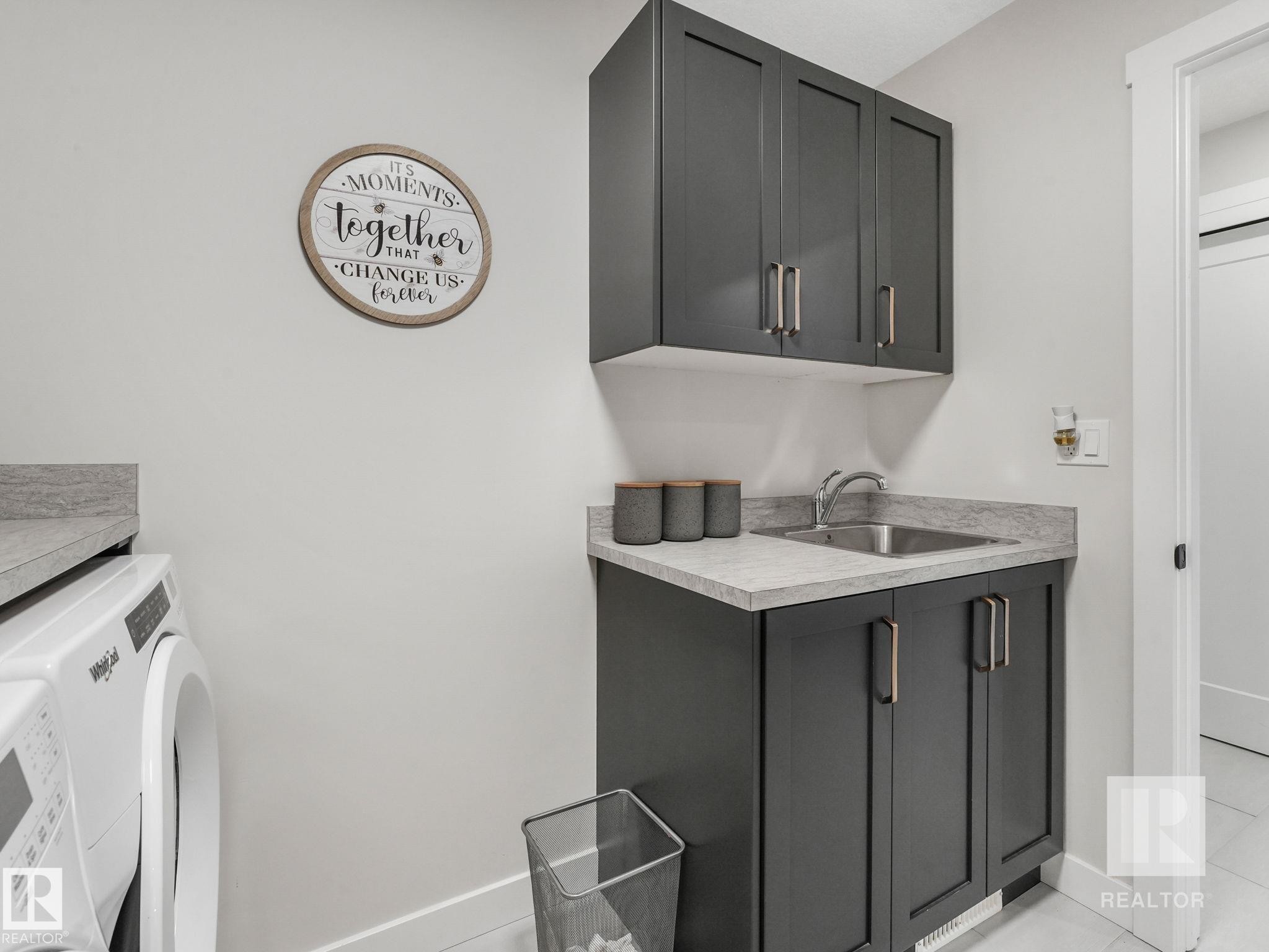 Laundry area with light tile patterned flooring and cabinet space - 209 55101 Ste. Anne Trail, Rural Lac Ste. Anne County, AB - Indoor Photo Showing Laundry Room