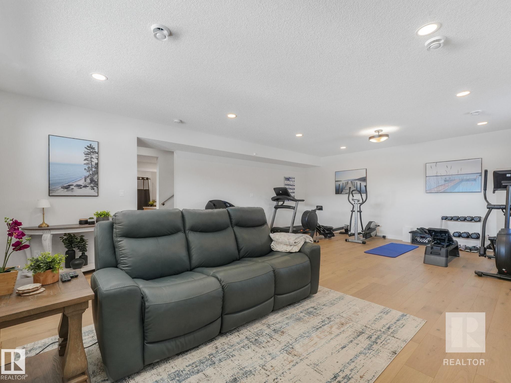 Living room with light wood-style flooring, recessed lighting, and a textured ceiling - 209 55101 Ste. Anne Trail, Rural Lac Ste. Anne County, AB - Indoor Photo Showing Other Room