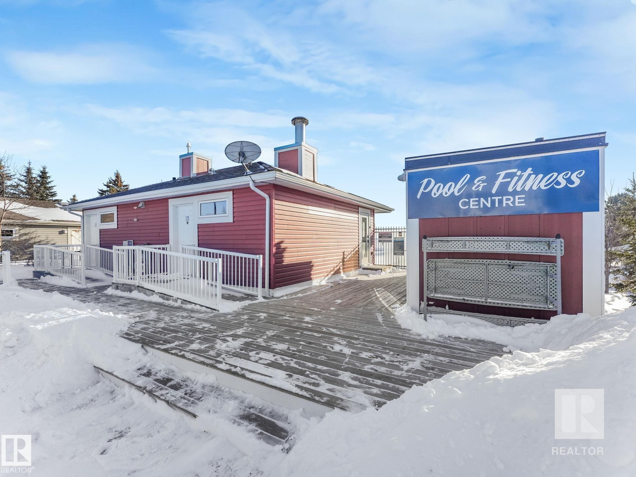 Snow covered property featuring a deck and a chimney - 209 55101 Ste. Anne Trail, Rural Lac Ste. Anne County, AB - Outdoor